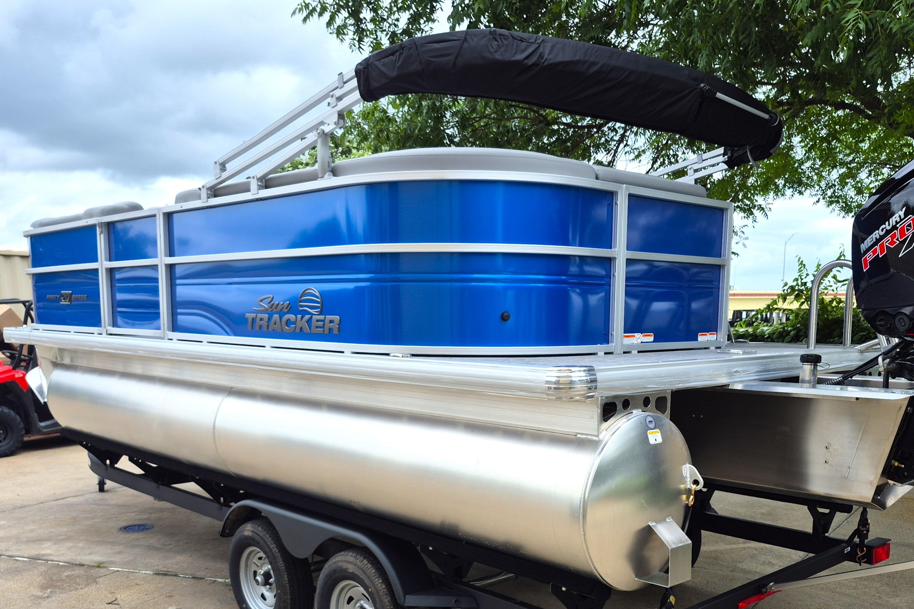 2026 Sun Tracker Party Barge 20 DLX pontoon boat with blue exterior on trailer.