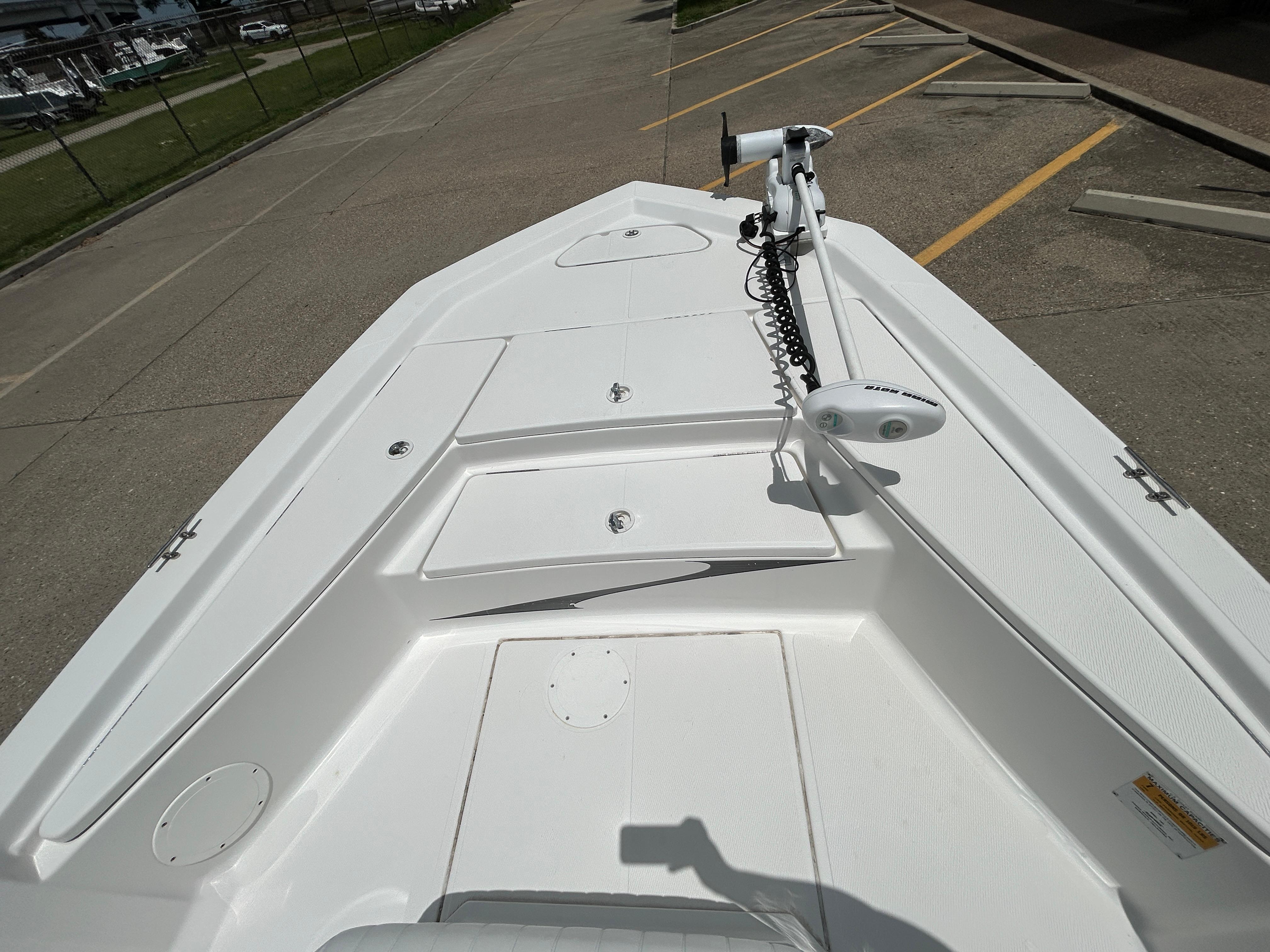 2012 Blue Wave 1900 STL boat deck with trolling motor, parked on concrete.
