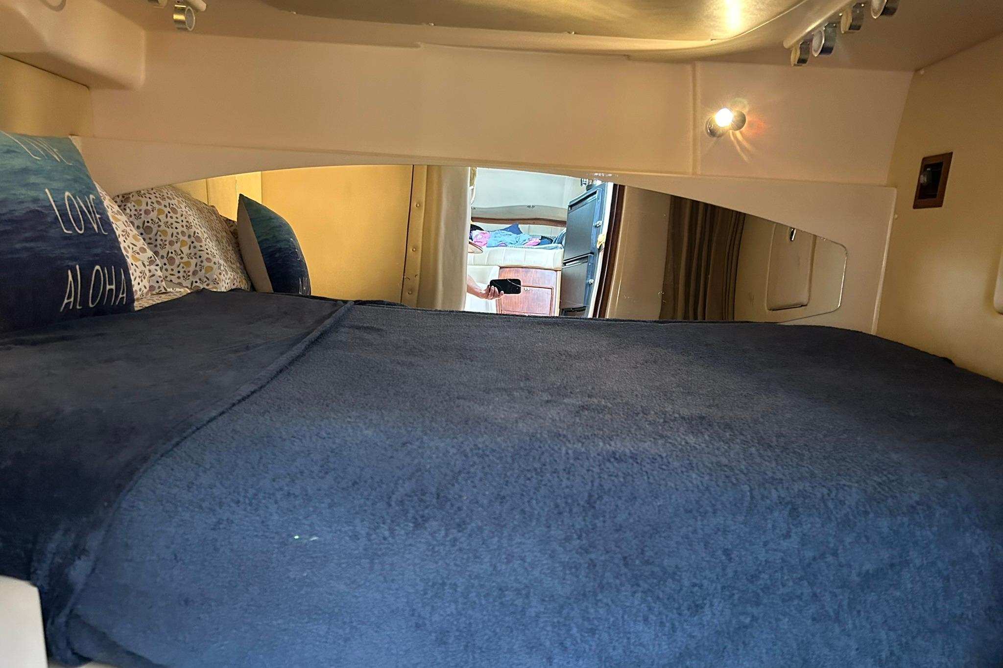Interior cabin of 2007 Grady-White Express 360 with cozy bedding and ambient lighting.
