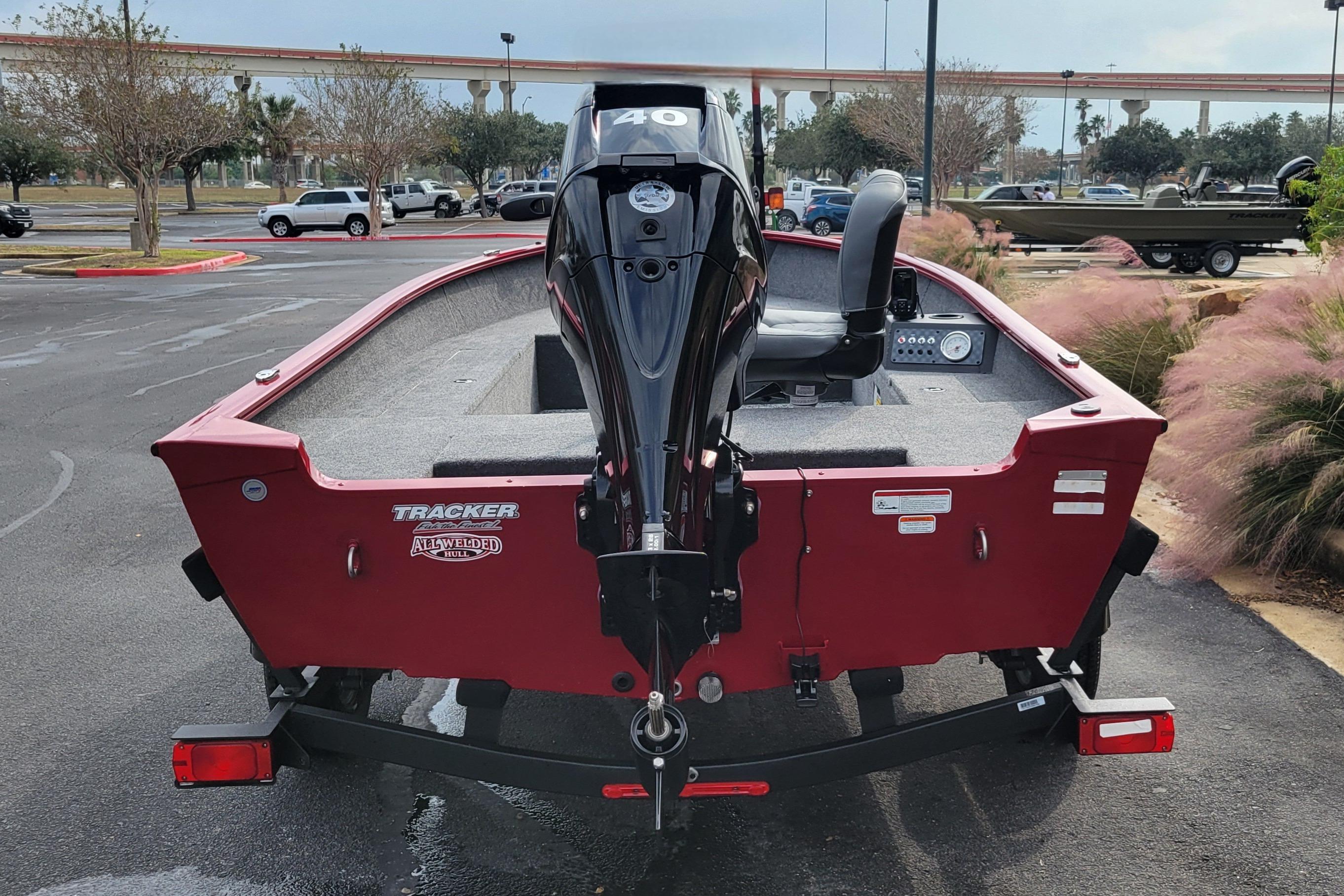 2025 Tracker Super Guide V-16 T boat with outboard motor, parked outdoors.