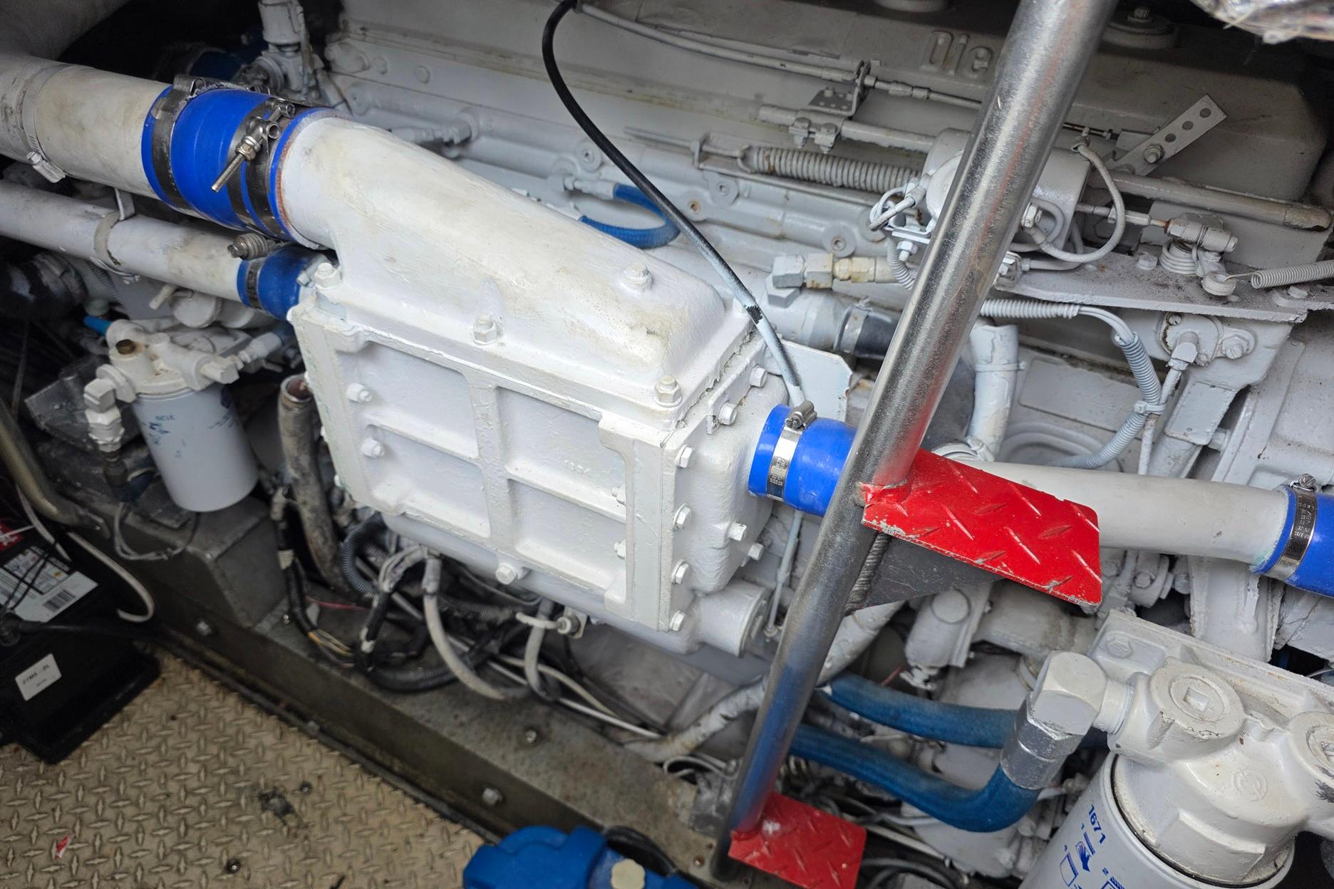 Engine compartment of a 1990 Topaz 39 Royale with visible pipes and components.