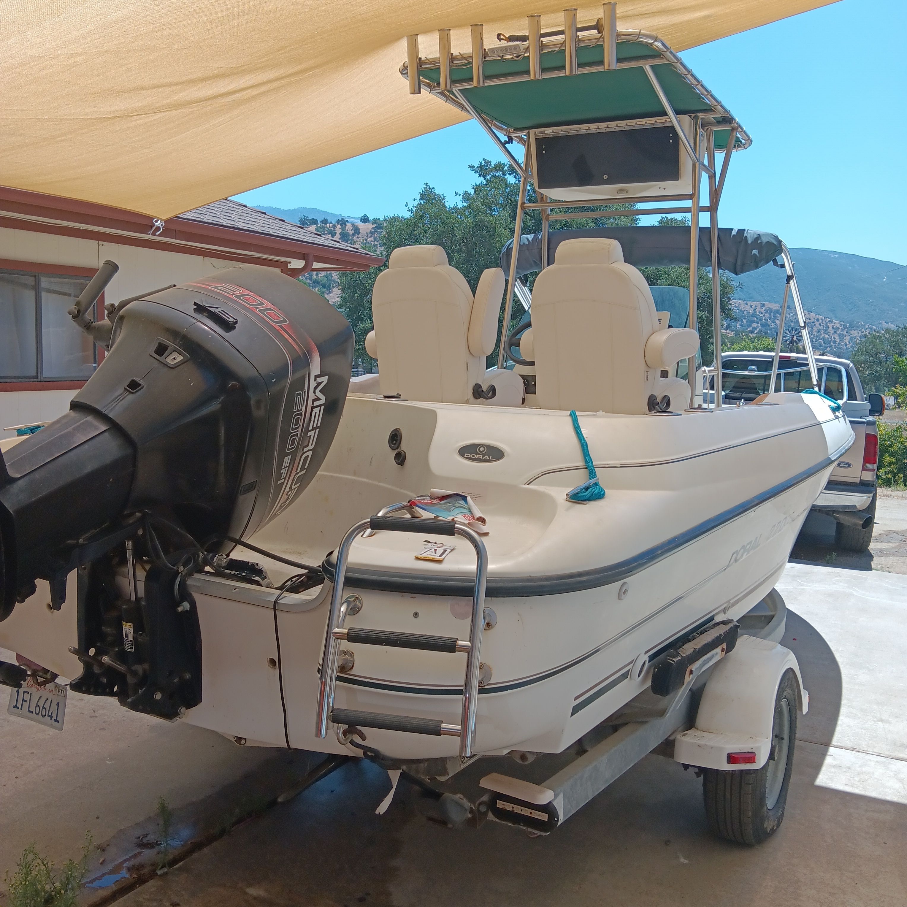 A 1998 Doral Ibiza 22 CC on a trailer under a sunshade.