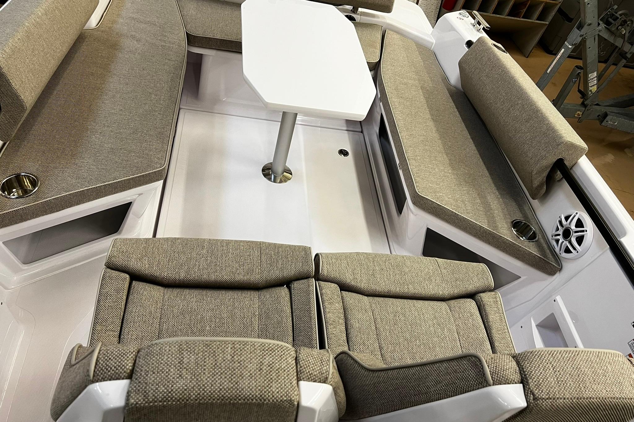 2025 Axopar 22 Spyder interior with beige seating and a central table.