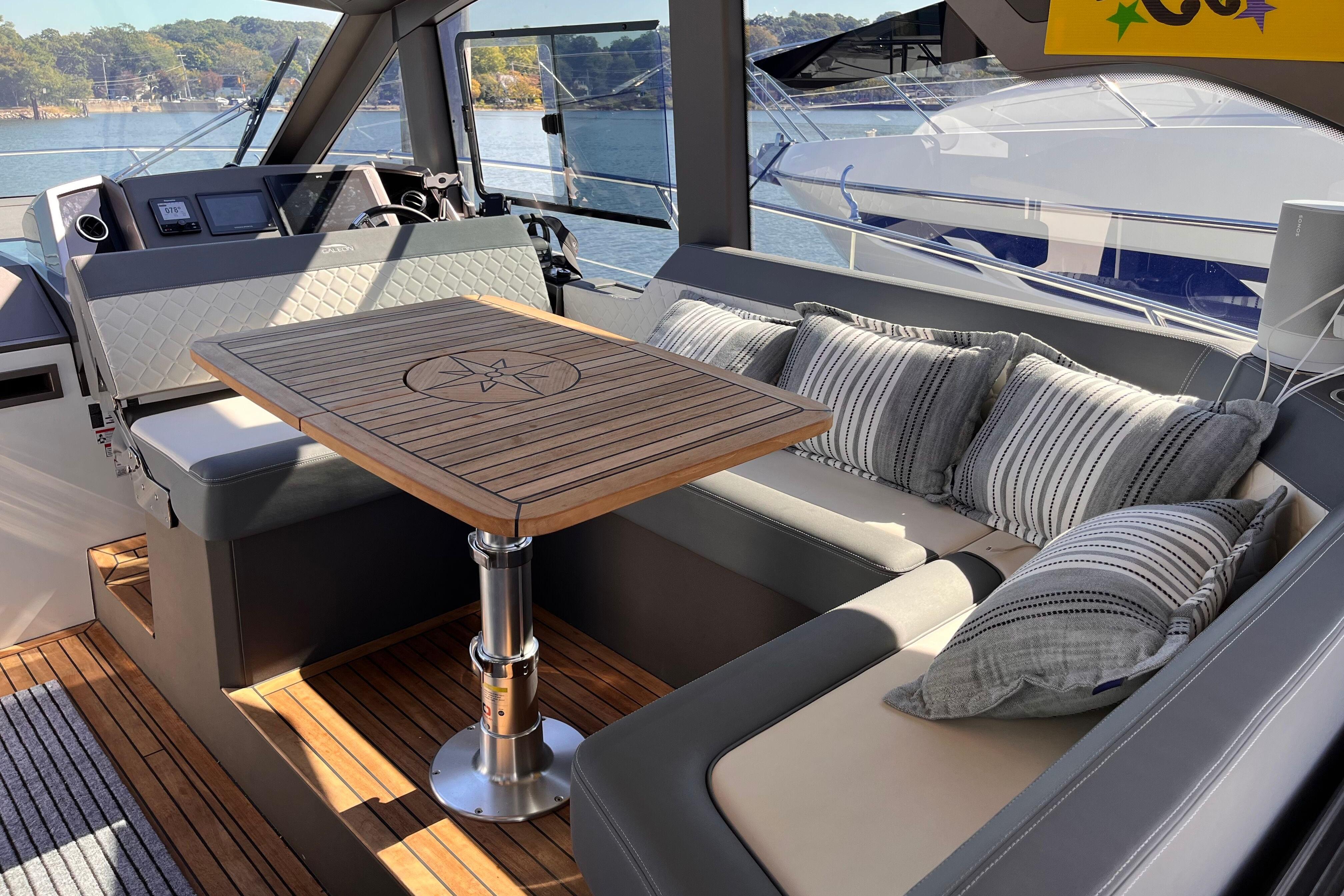 Luxurious interior of 2024 Galeon 425 HTS yacht with elegant seating and wooden table.