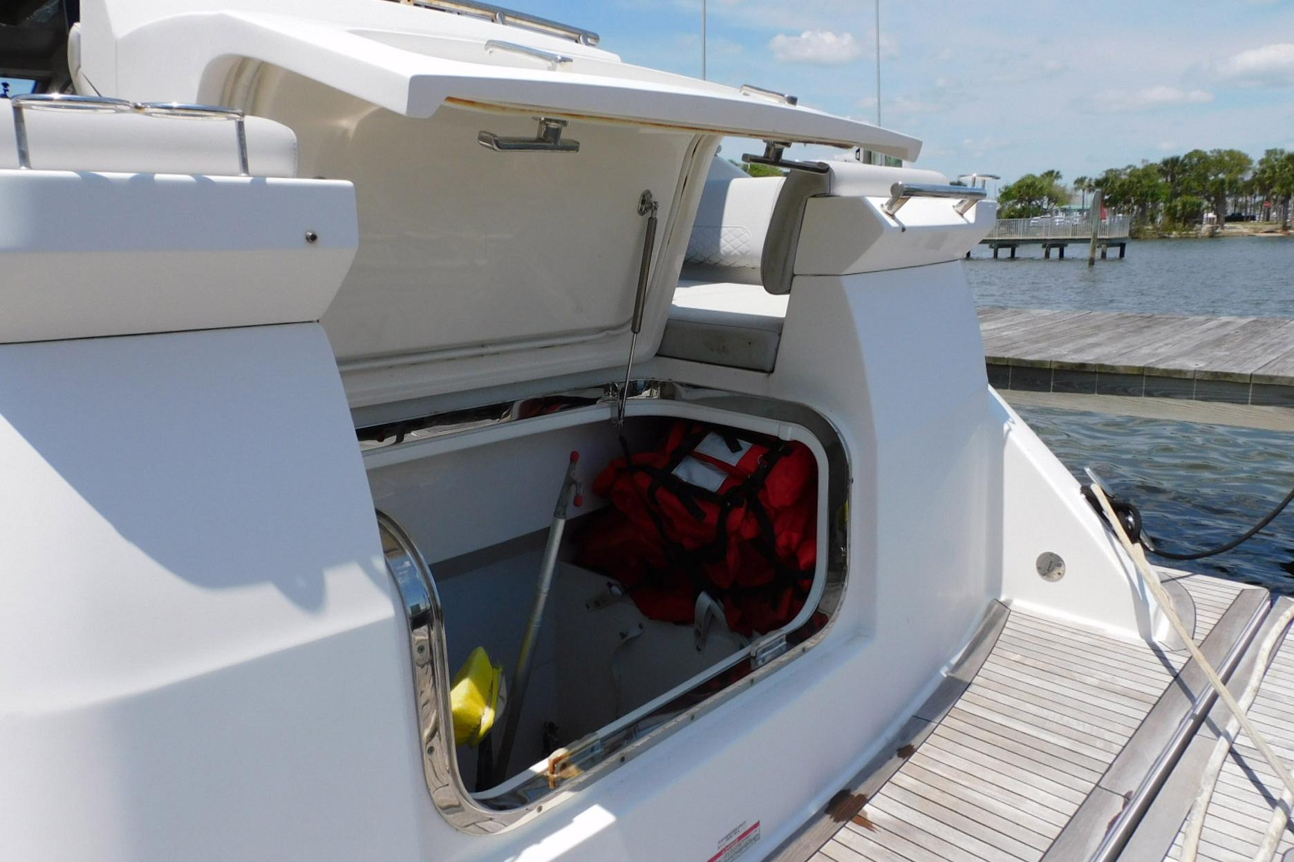 Open storage compartment on 2019 Sea Ray L550 yacht docked by the water.
