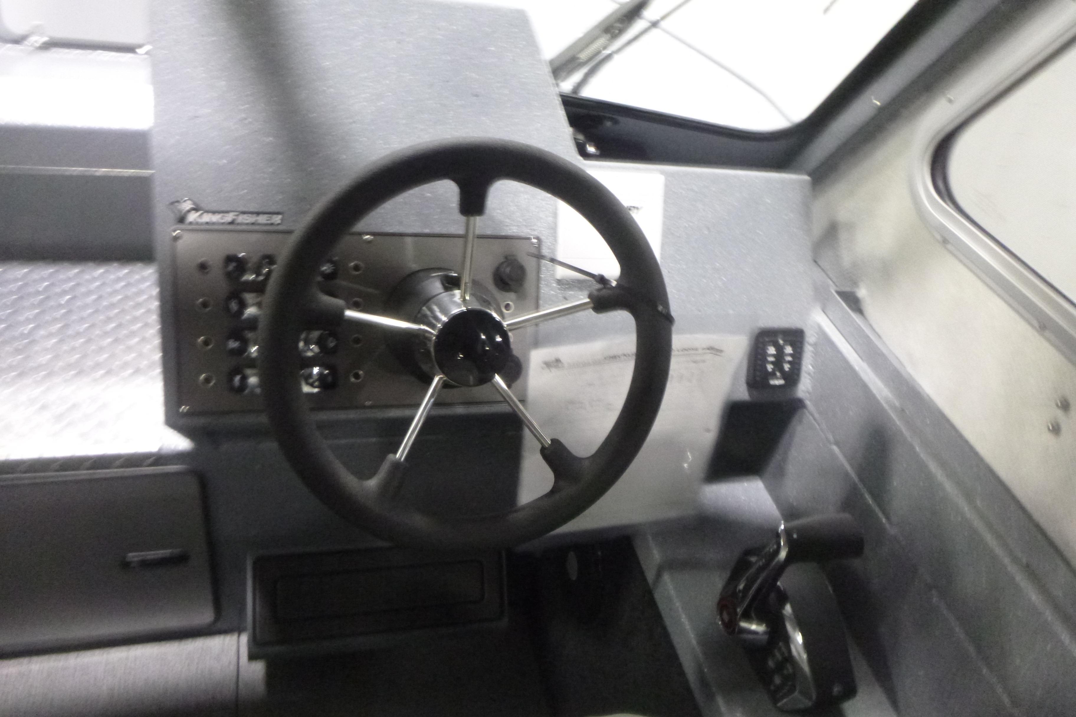Steering console of 2026 KingFisher 2425 Escape HT boat, featuring modern controls and dashboard.