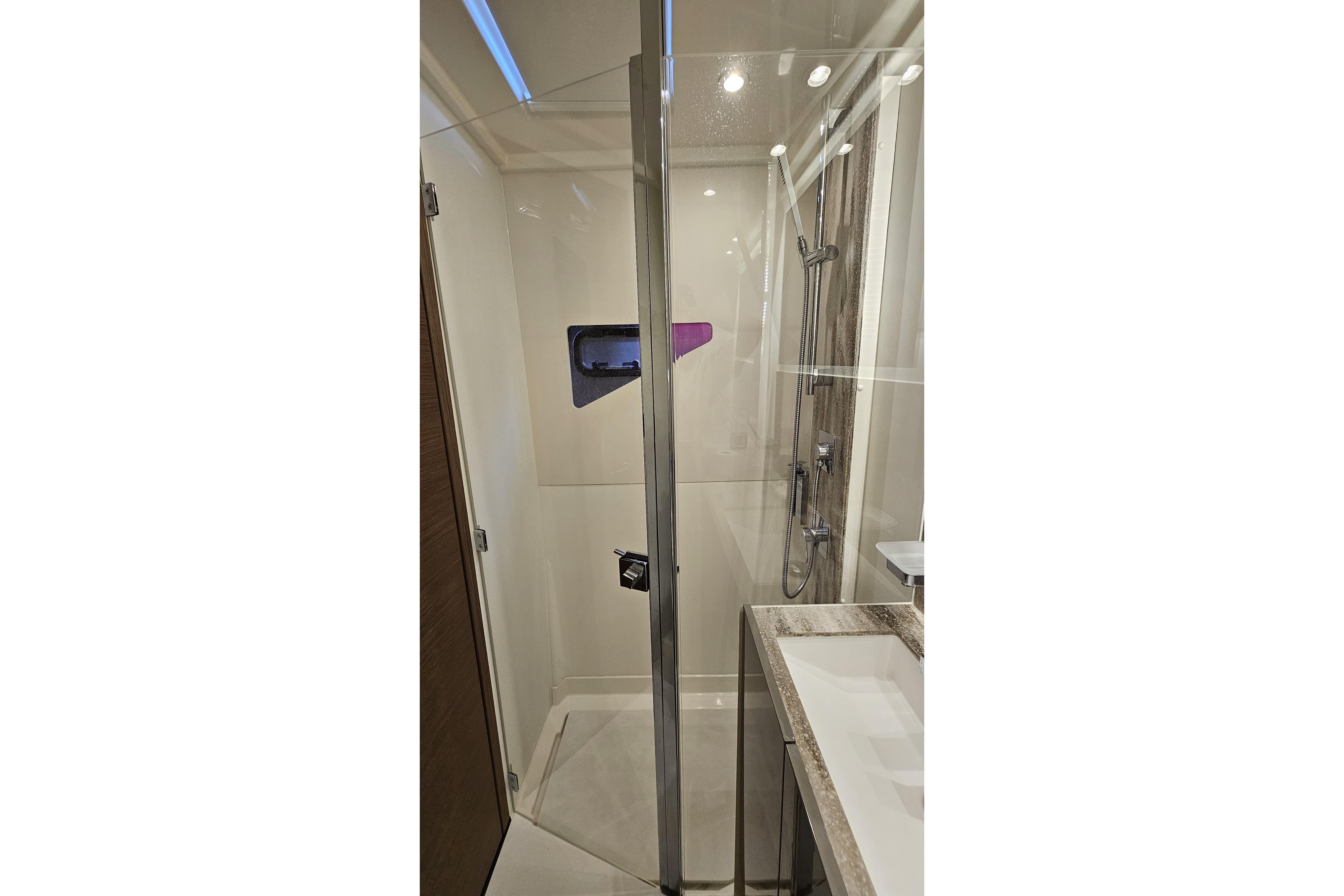 Modern shower in 2024 Prestige M48 yacht, featuring glass door and sleek fixtures.