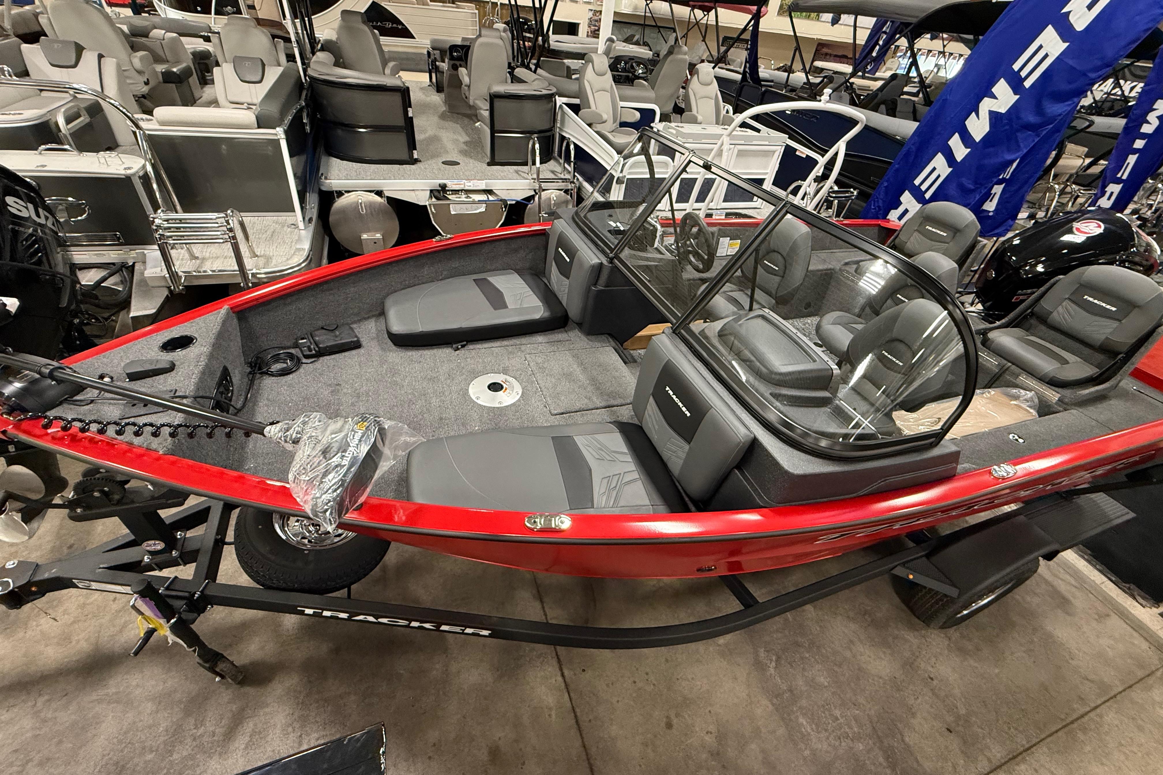 2026 Tracker Pro Guide V-175 Combo boat, red exterior, displayed indoors with seating and windshield.