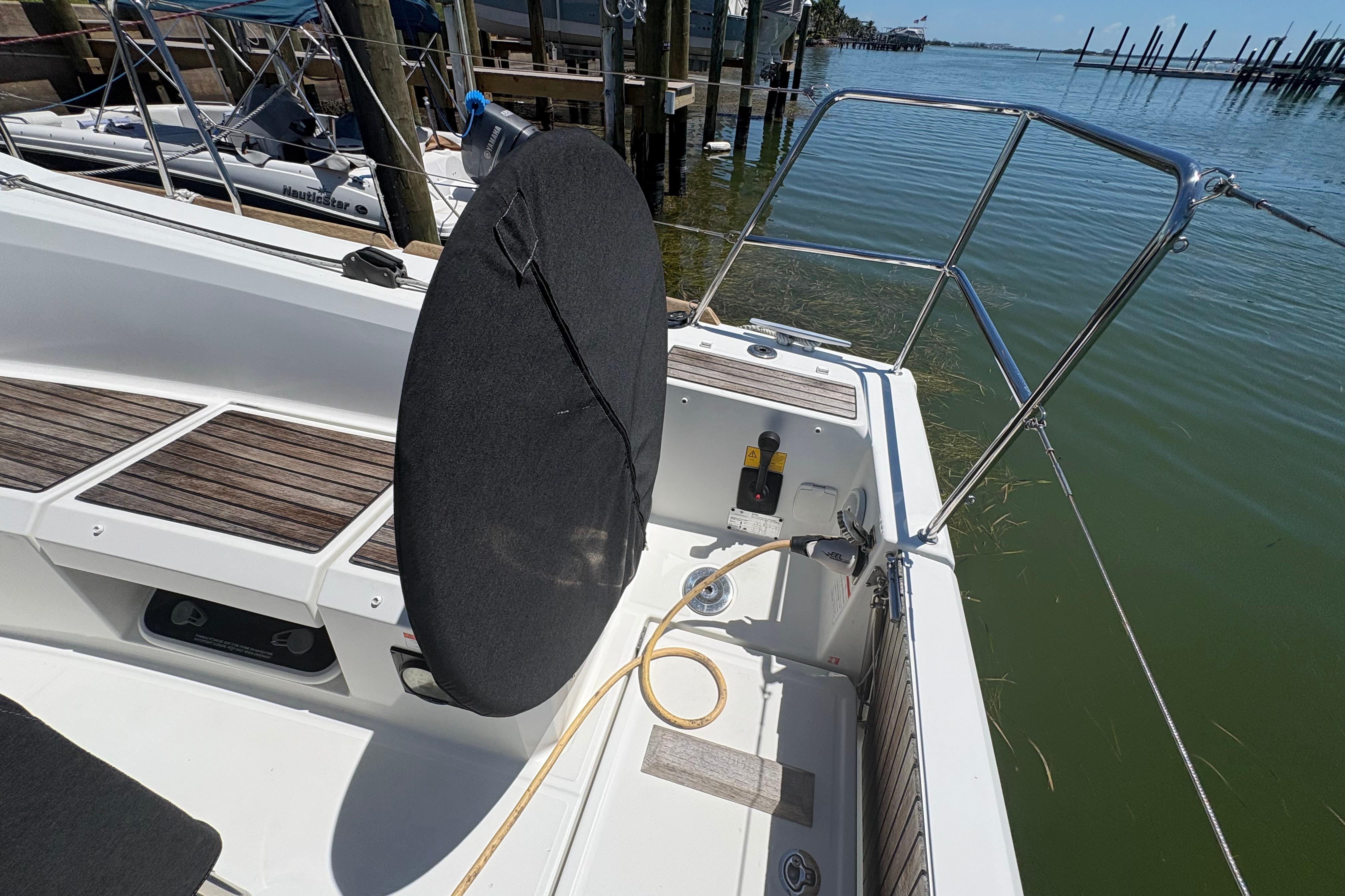 Cockpit of 2021 Jeanneau Sun Odyssey 349 sailboat with wooden seating and steering wheel.