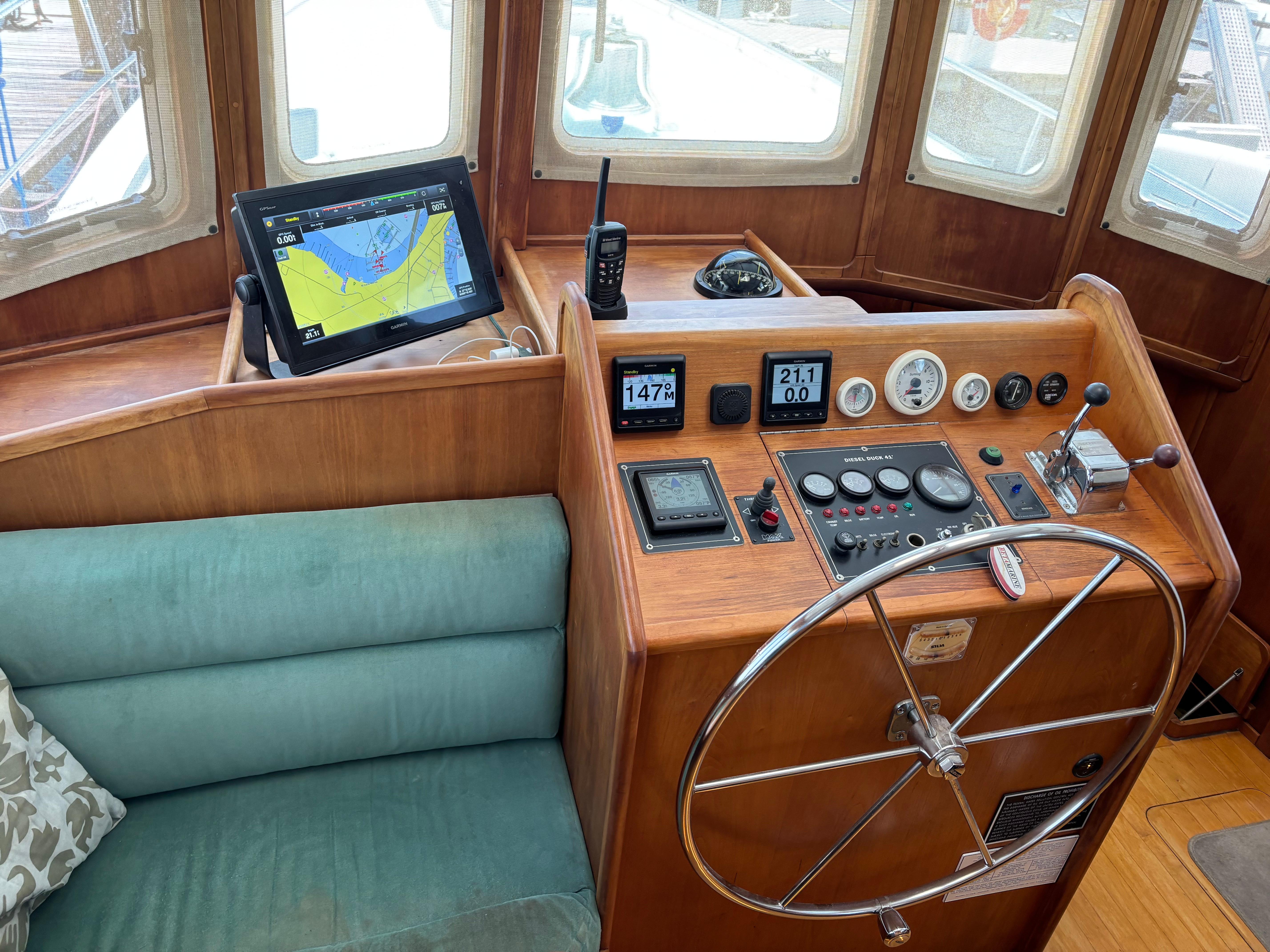 1999 Diesel Duck Trawler helm with navigation equipment and steering wheel.