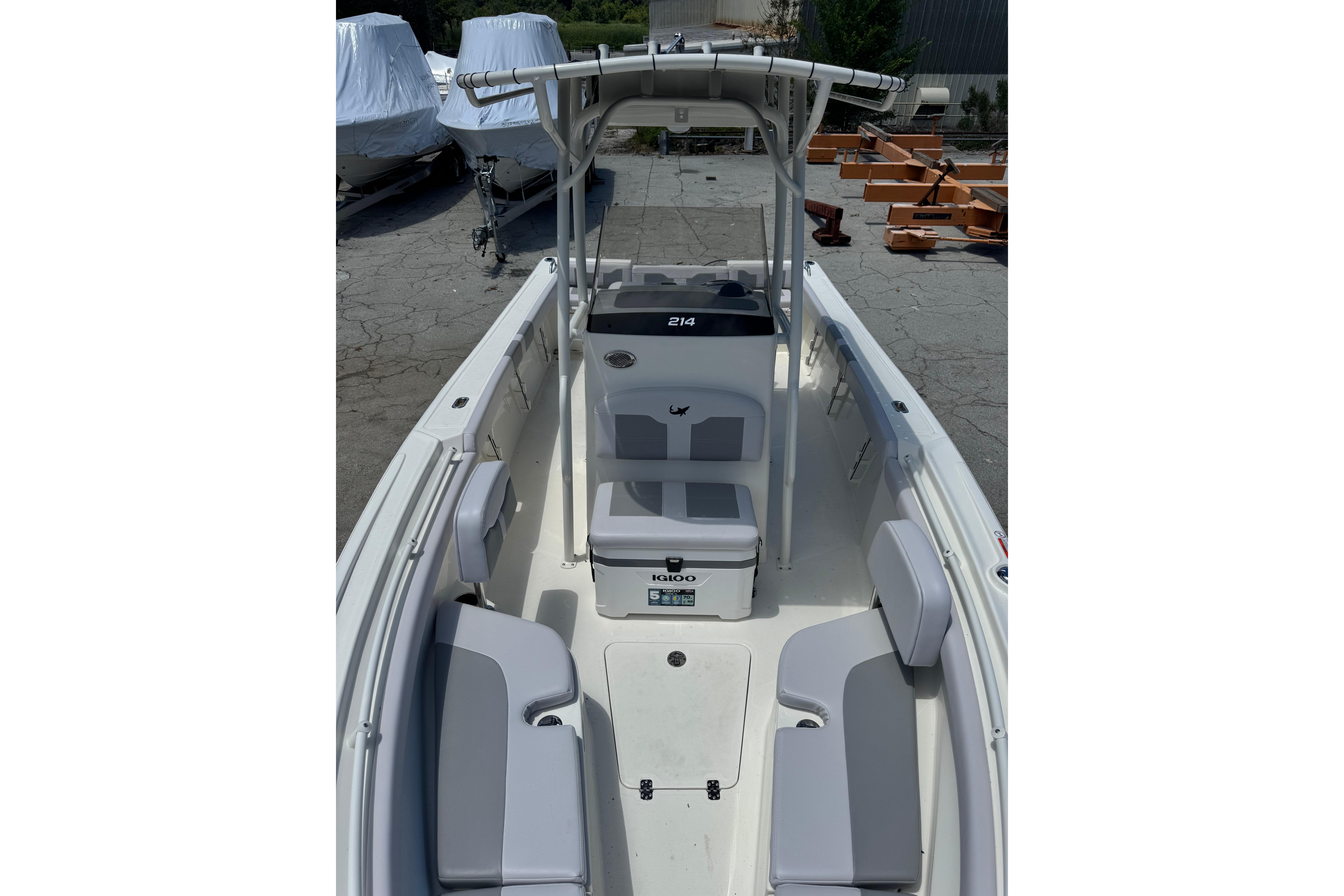 2026 Mako 214 Center Console boat with seating and T-top in a marina setting.