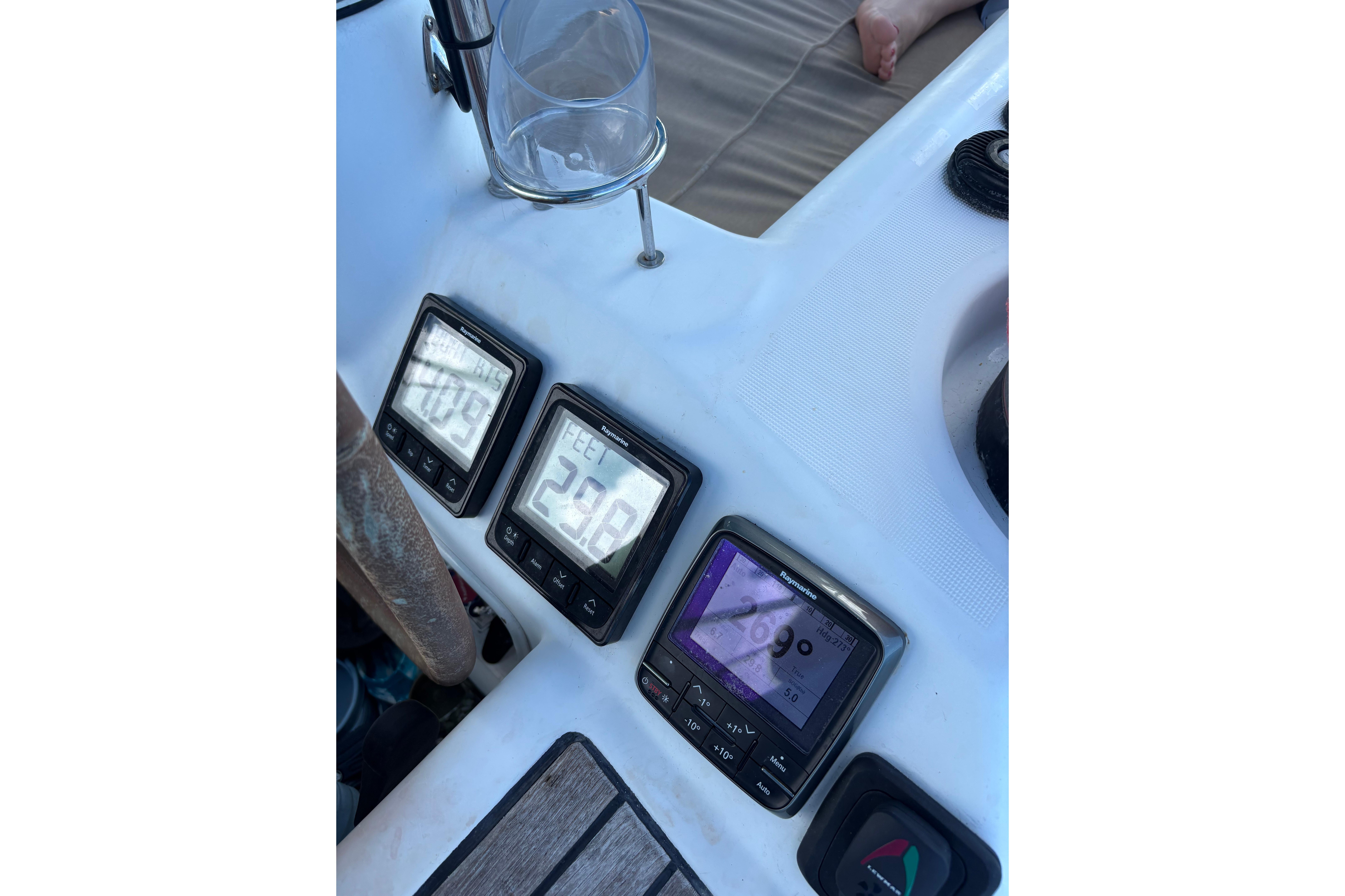 Beneteau Oceanis 46 cockpit instruments, 2010 model, displaying navigation data with a glass holder nearby.