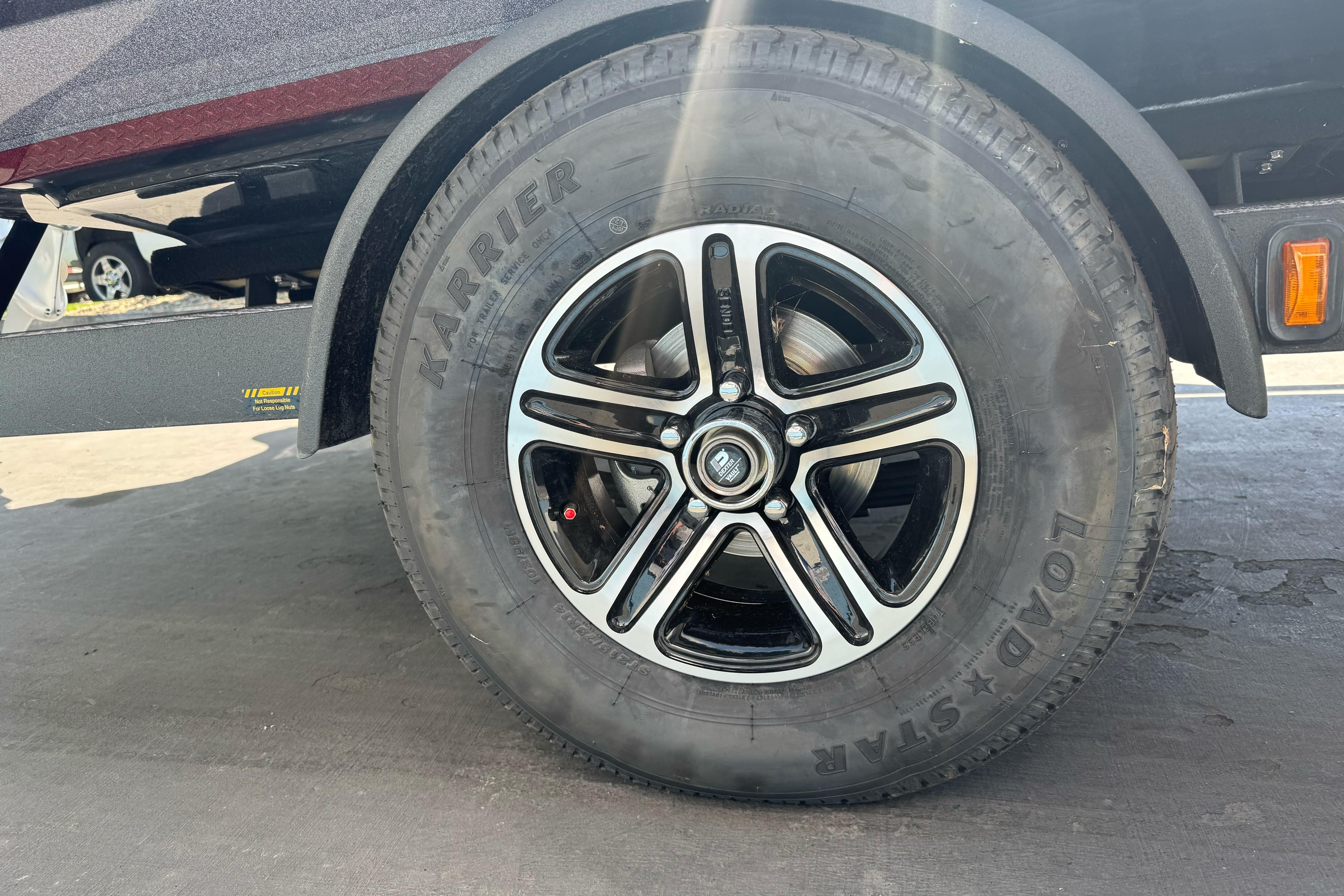 2026 Triton 18 TrX trailer wheel with black alloy rim and Karrie tire.