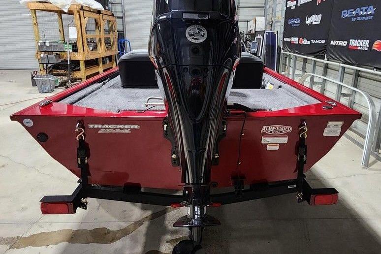 2026 Tracker Pro 170 boat in a showroom, featuring a sleek red design and powerful outboard motor.