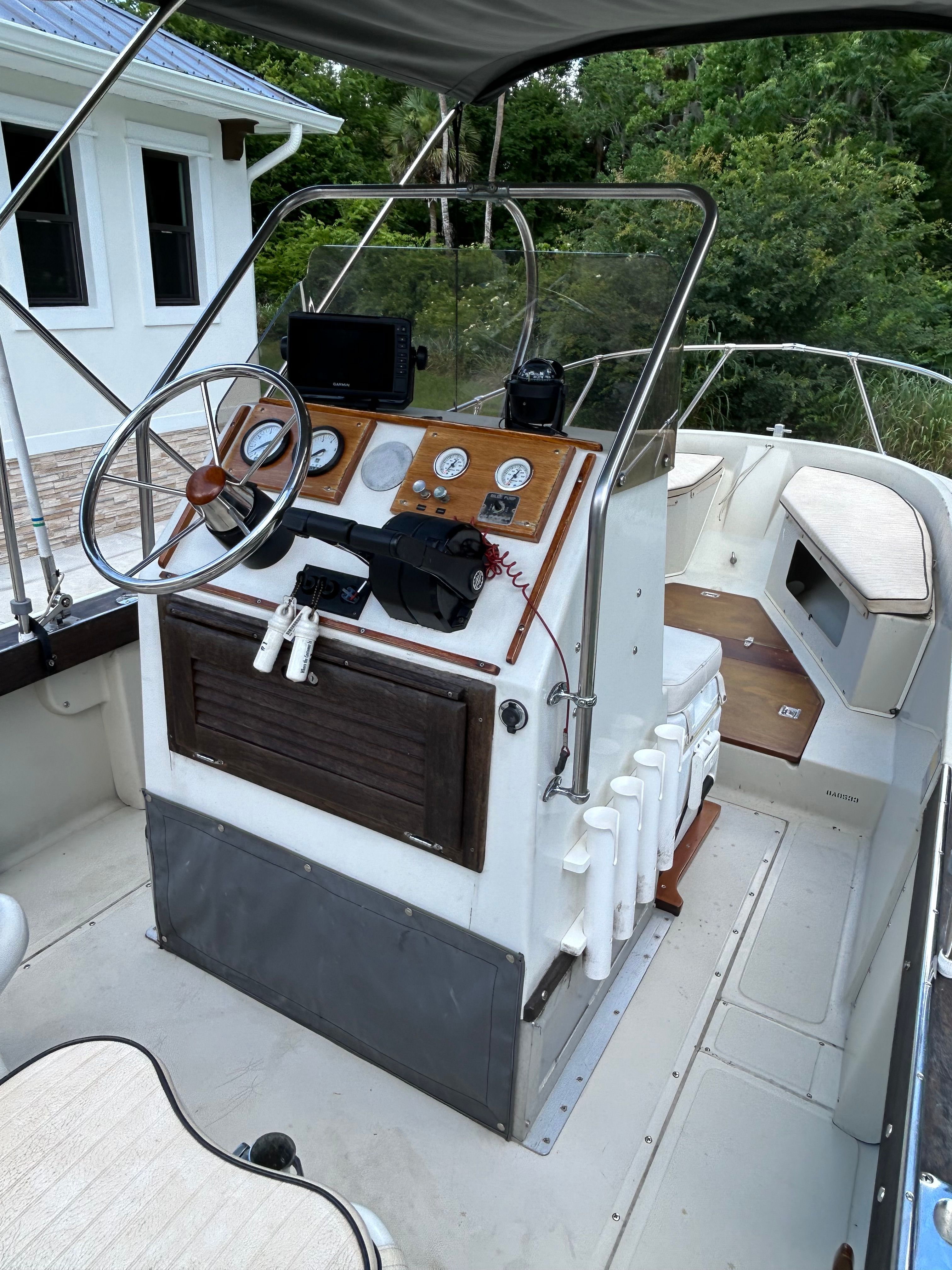 The image shows the cockpit of a 1981 Boston Whaler OUTRAGE with a helm console and instruments.
