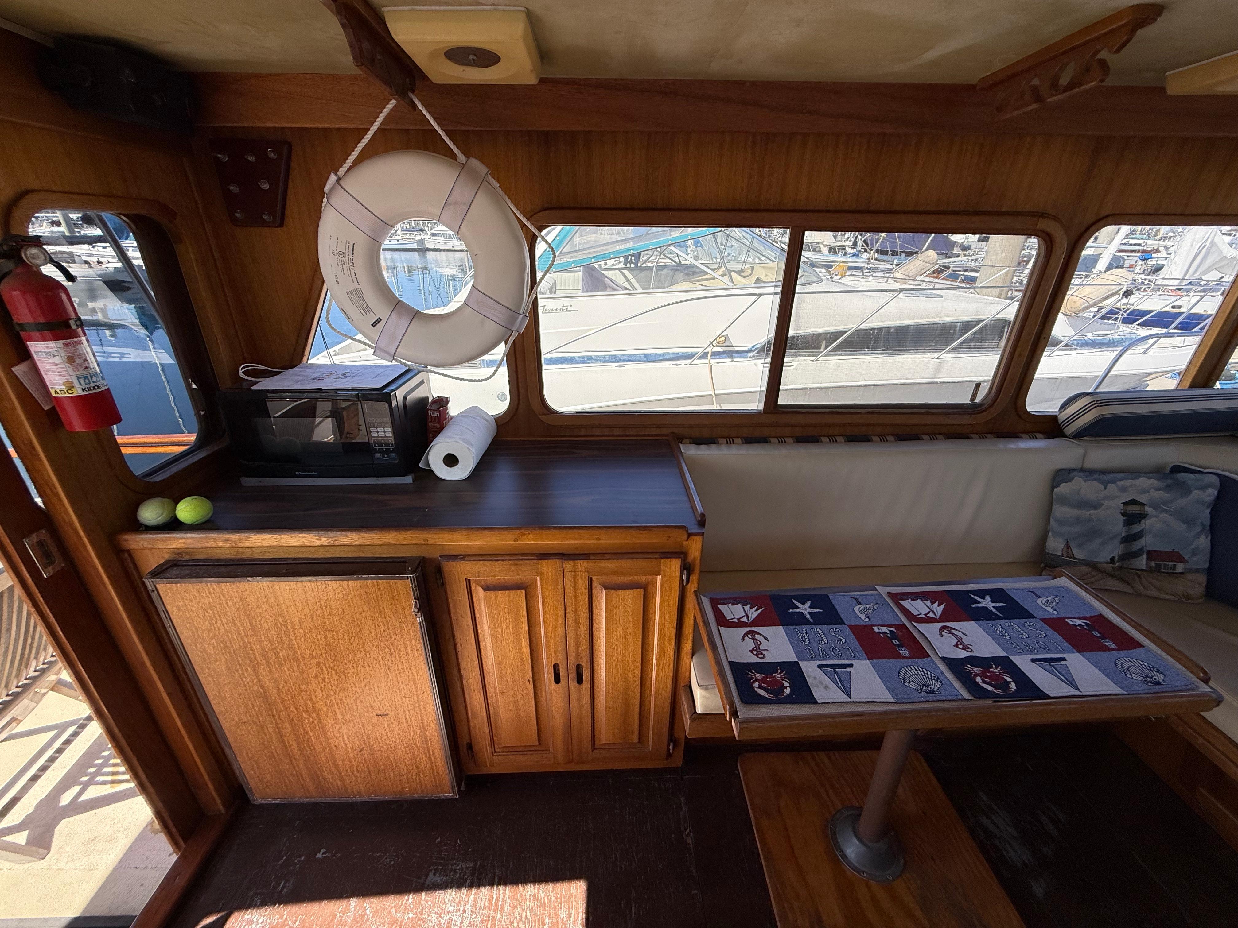 Interior of a 1983 Californian 34 boat with wooden cabinetry and nautical decor.