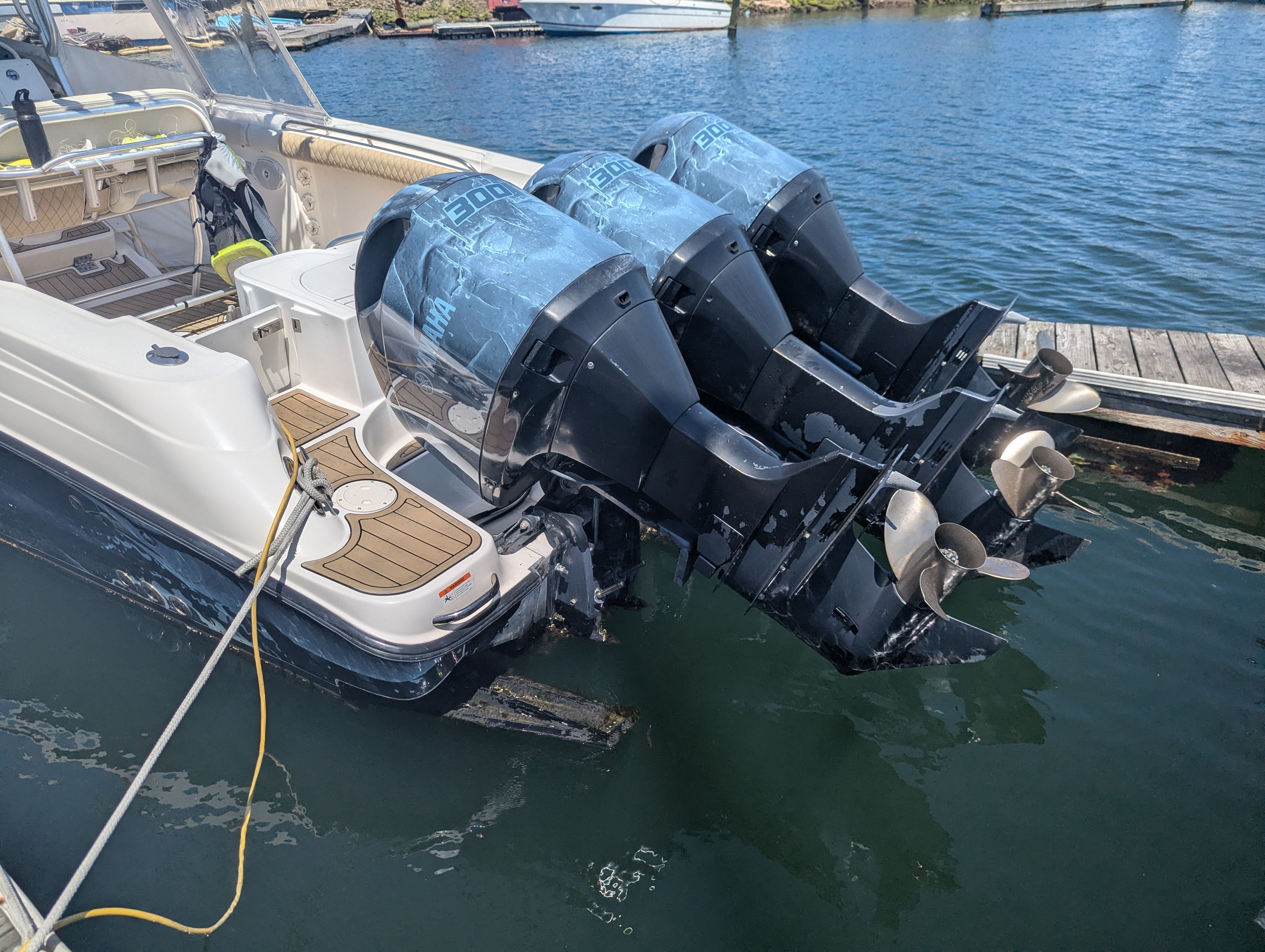 2005 Wellcraft 35 CCF boat with triple outboard engines at dock.