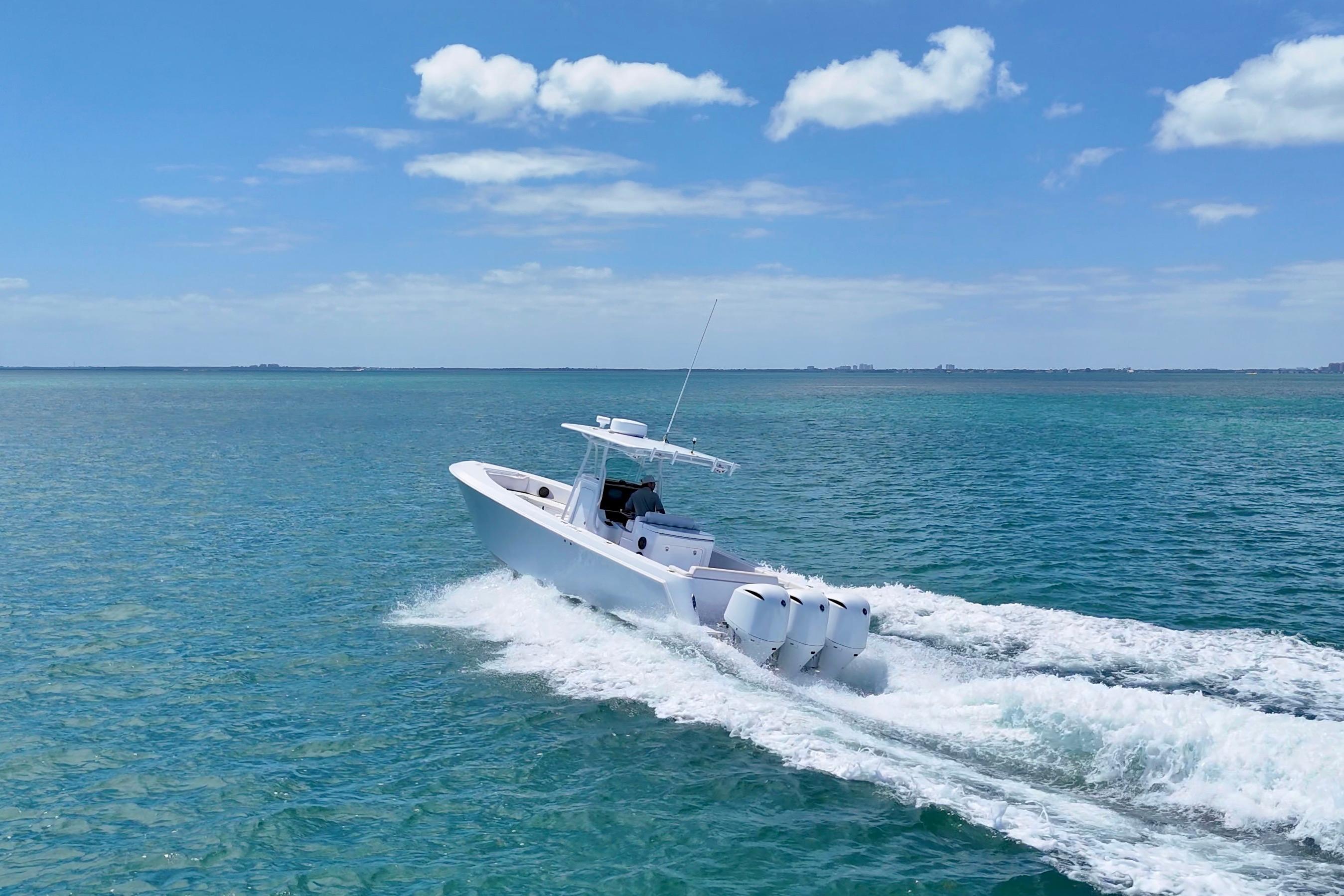 2013 Contender 35 LS boat cruising on clear blue ocean under a sunny sky.