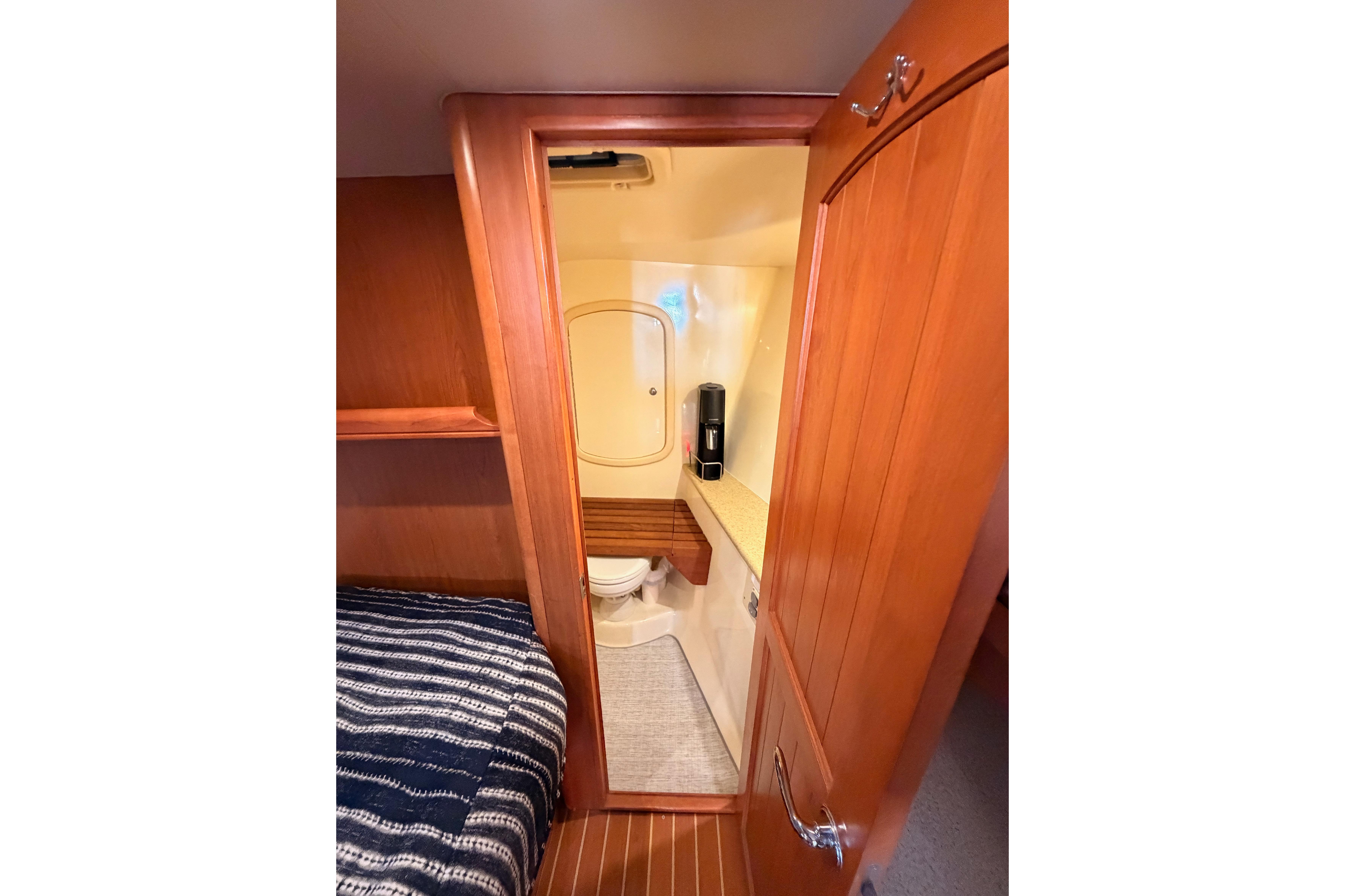Interior view of 2008 Hunter 45 Deck Salon yacht bathroom with wooden cabinetry.
