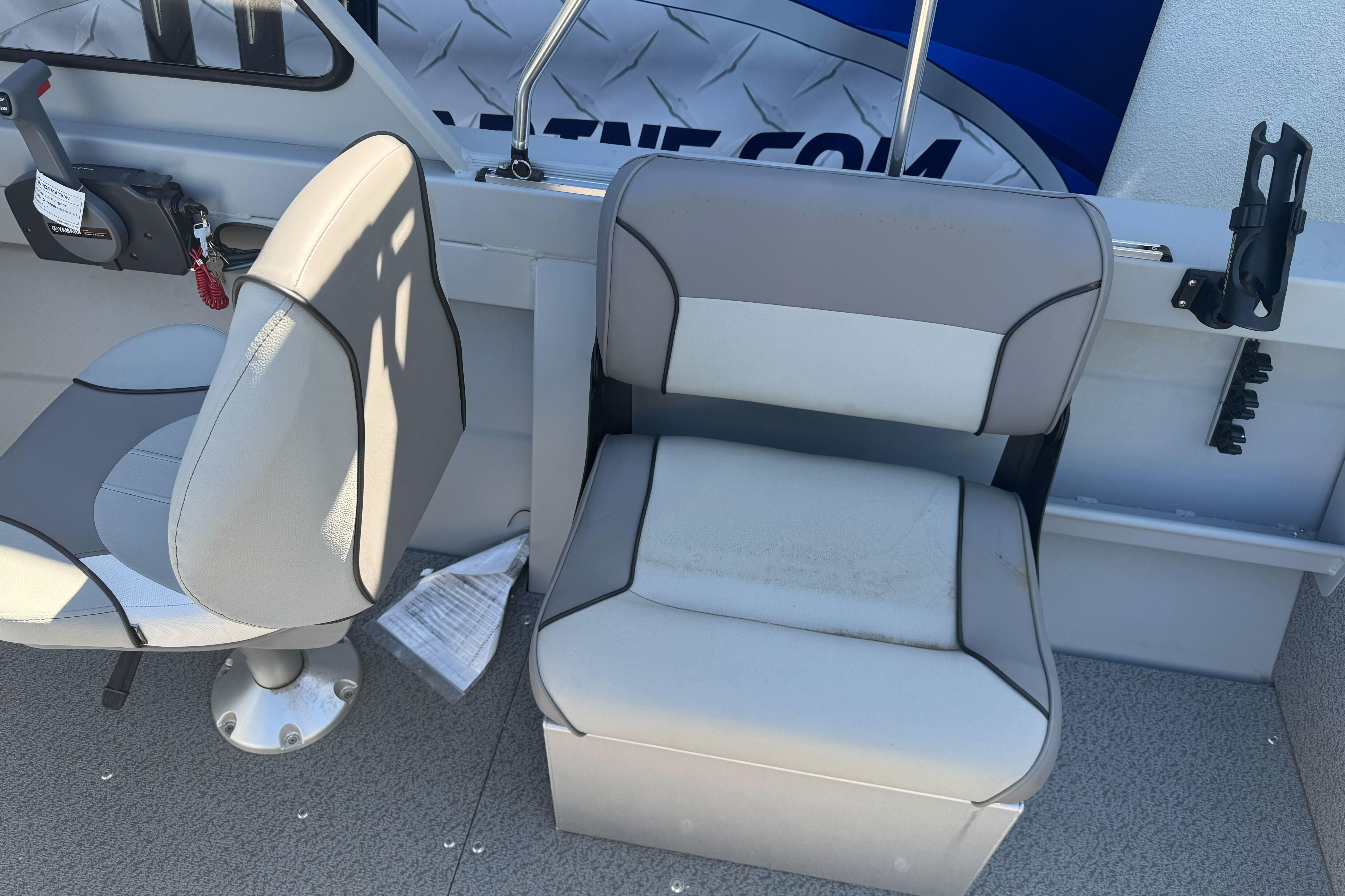 Interior of 2026 KingFisher 16 Falcon boat with gray seating and control panel.