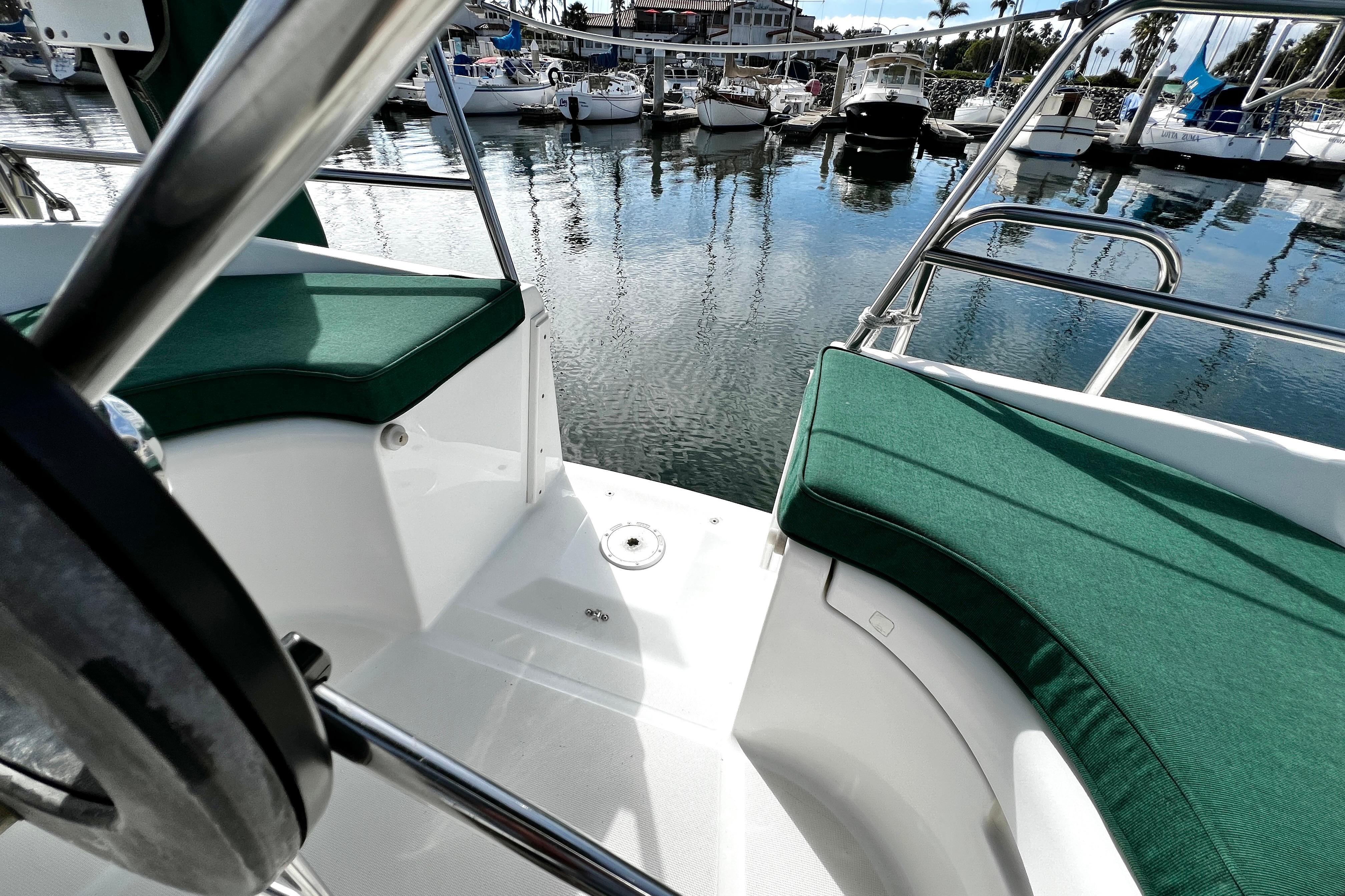 Cockpit view of 2002 Beneteau 331 sailboat with green cushions in marina.