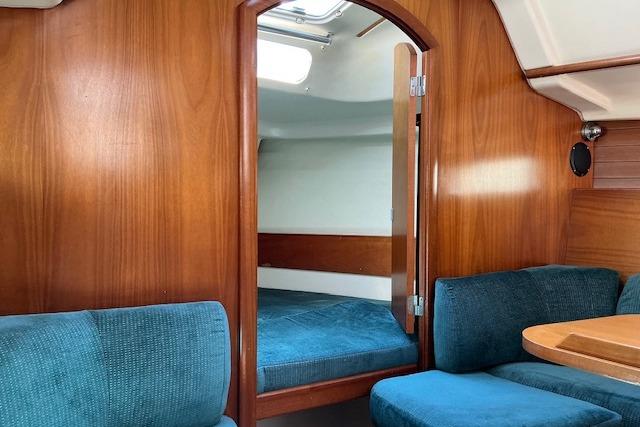 Interior of 2000 Beneteau Oceanis 321 sailboat with wood paneling and blue seating.