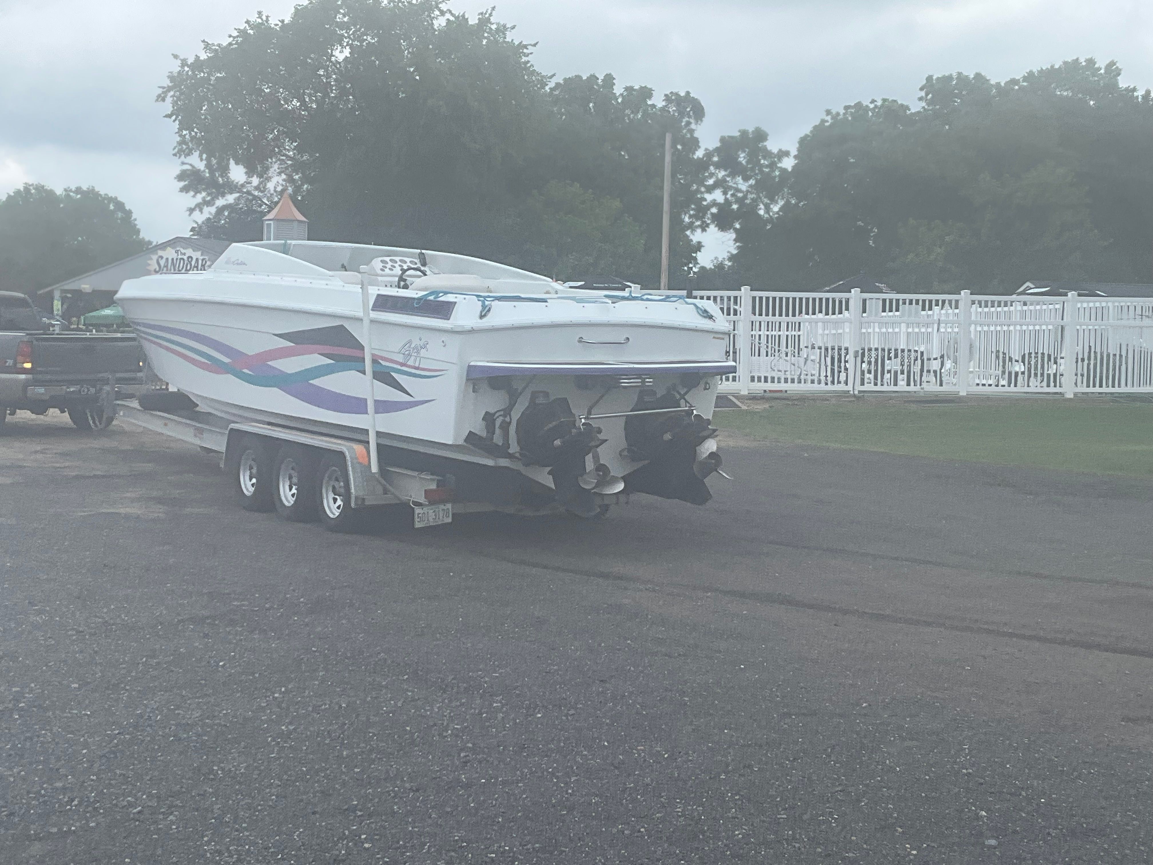 A 1995 Baja Caliber boat on a trailer, ready for transport.