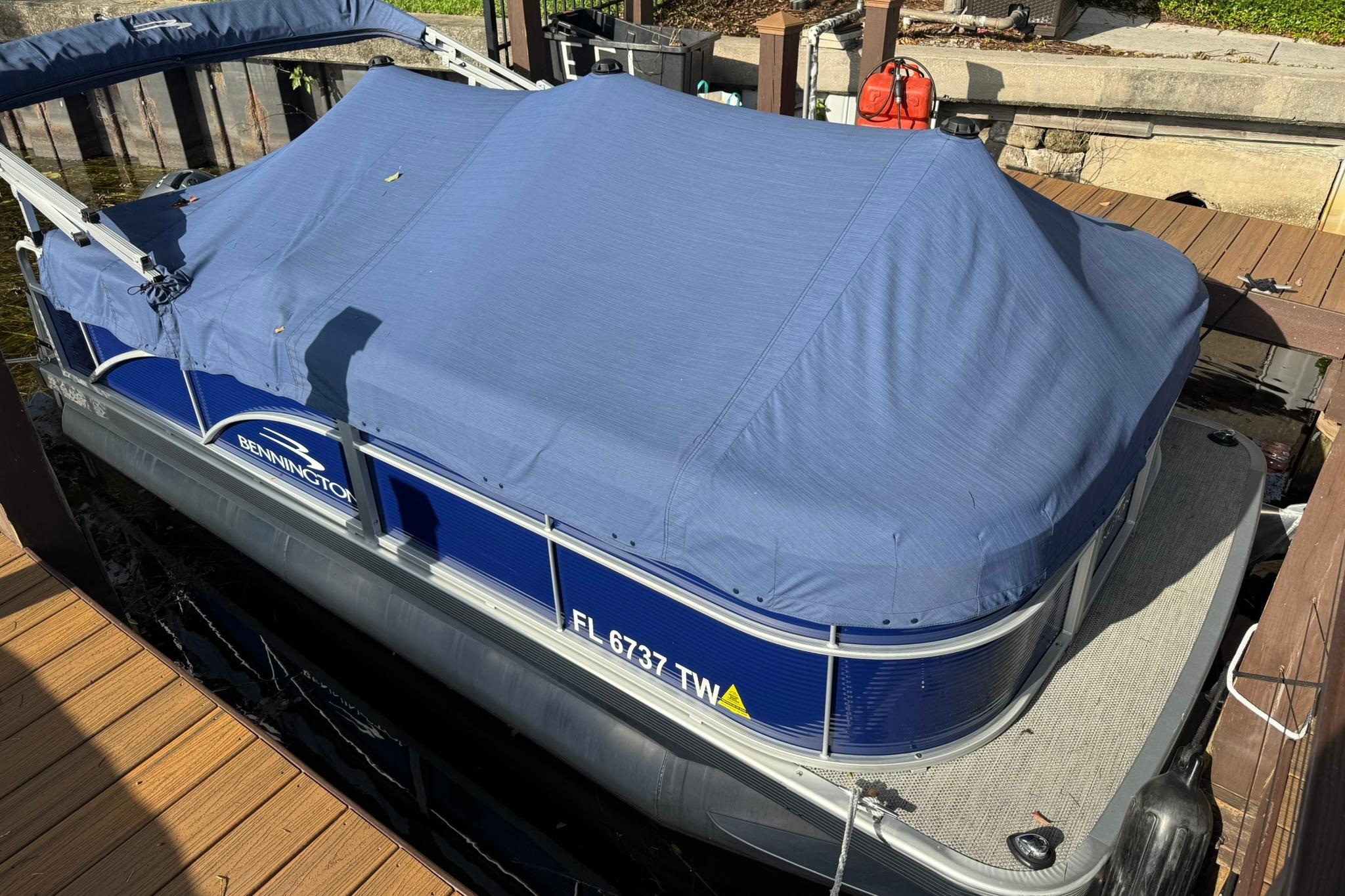 2024 Bennington SV 168 SLV pontoon boat with blue cover docked.