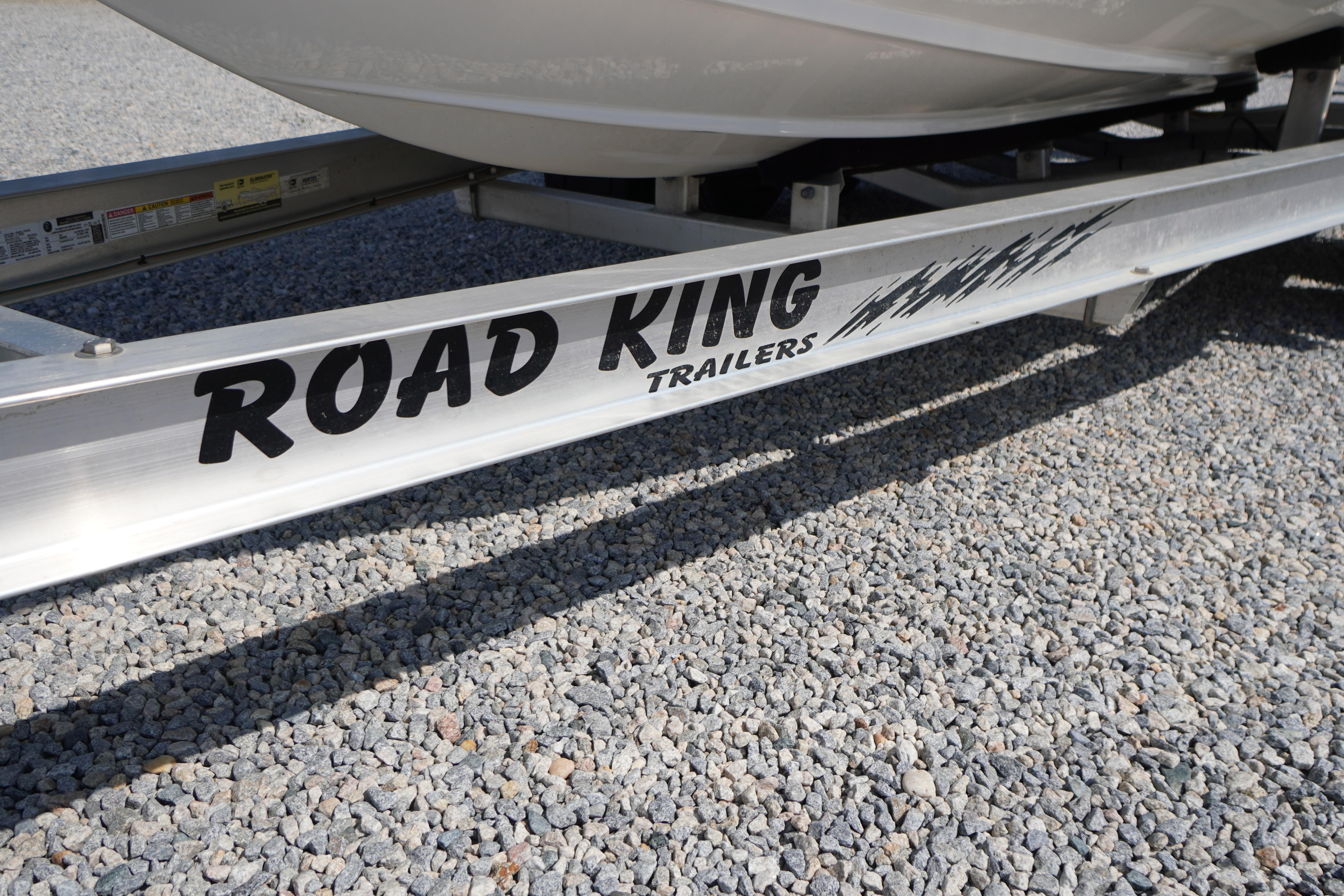 Trailer for 2025 Tidewater 232 SS boat on gravel surface.