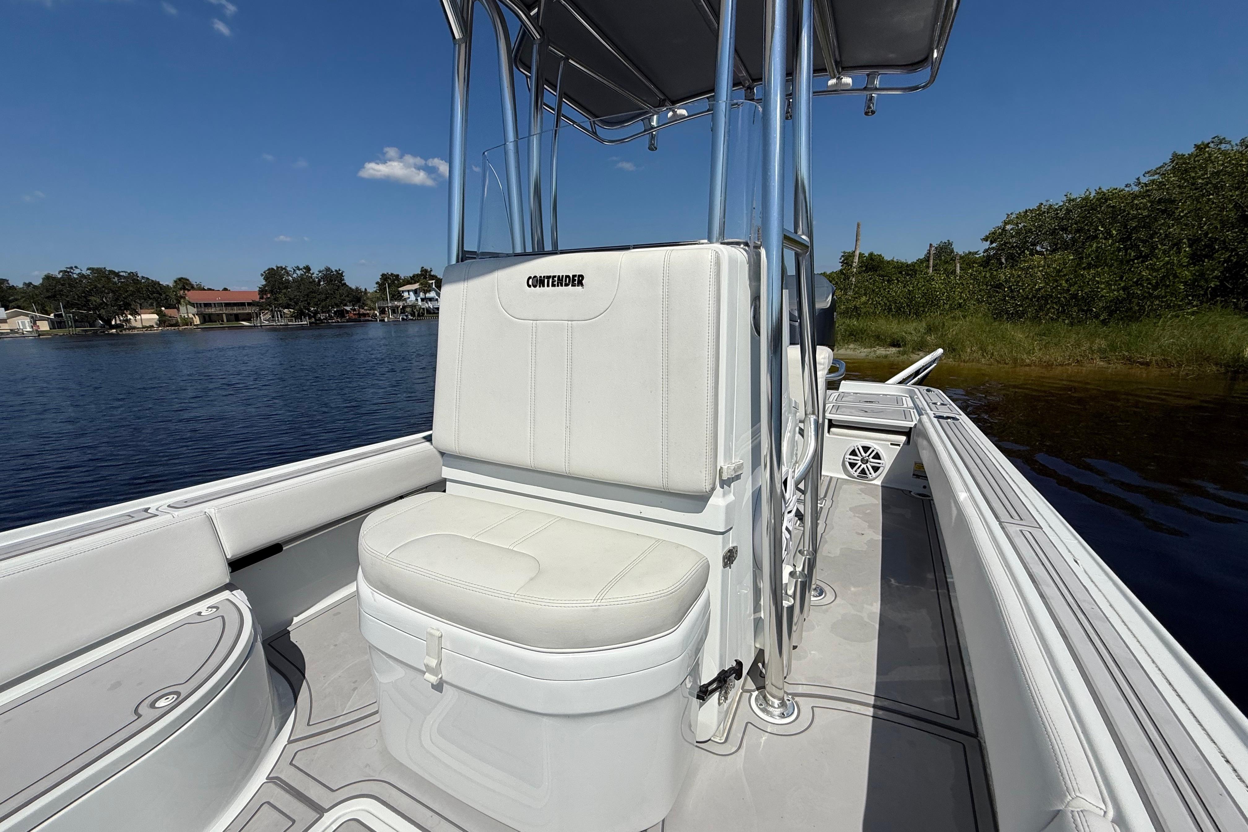 2024 Contender 26 Bay boat interior with white seating and console, on calm water.