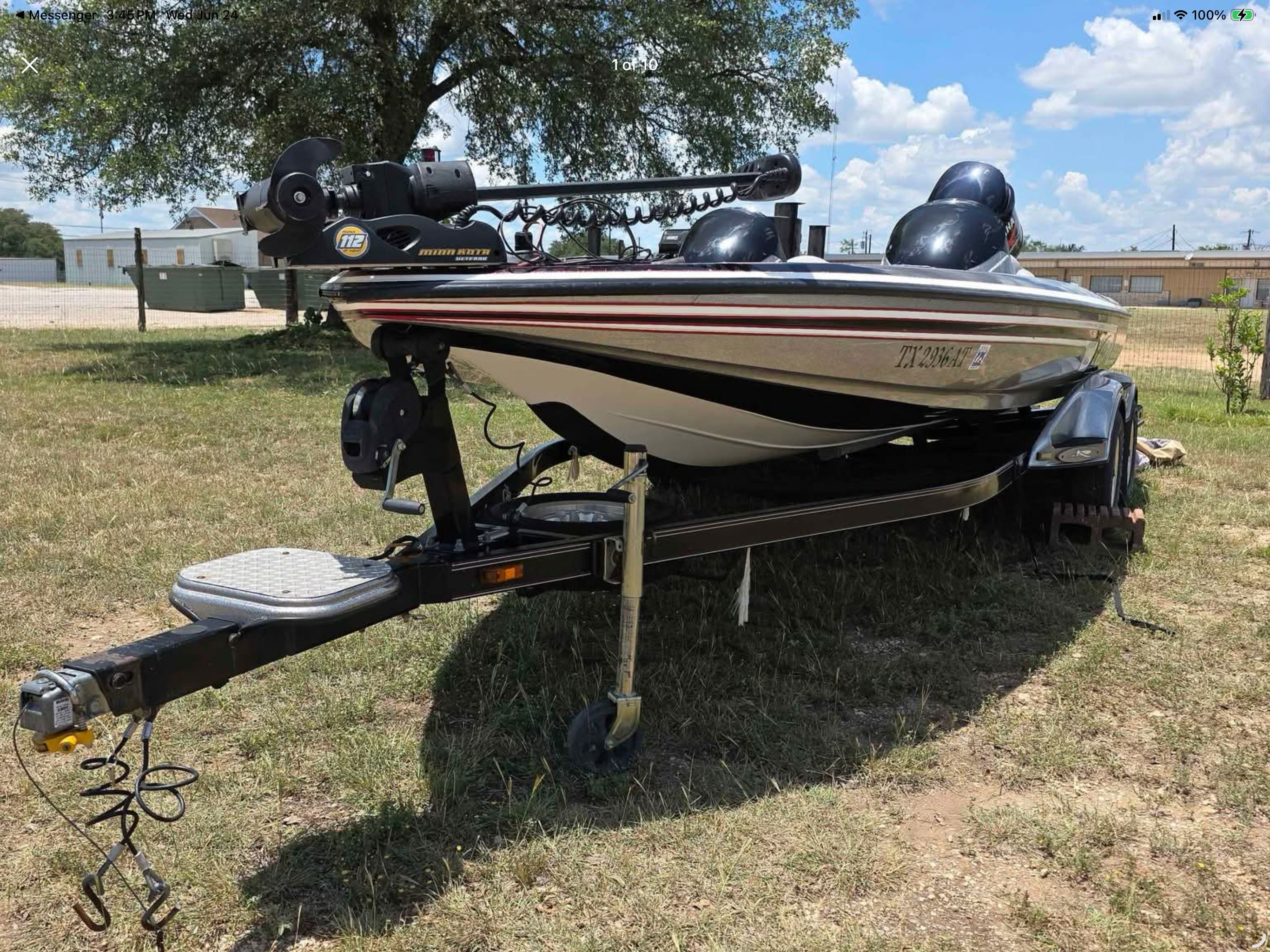 A 2006 Skeeter 20i boat on a trailer, parked on grass under a tree.
