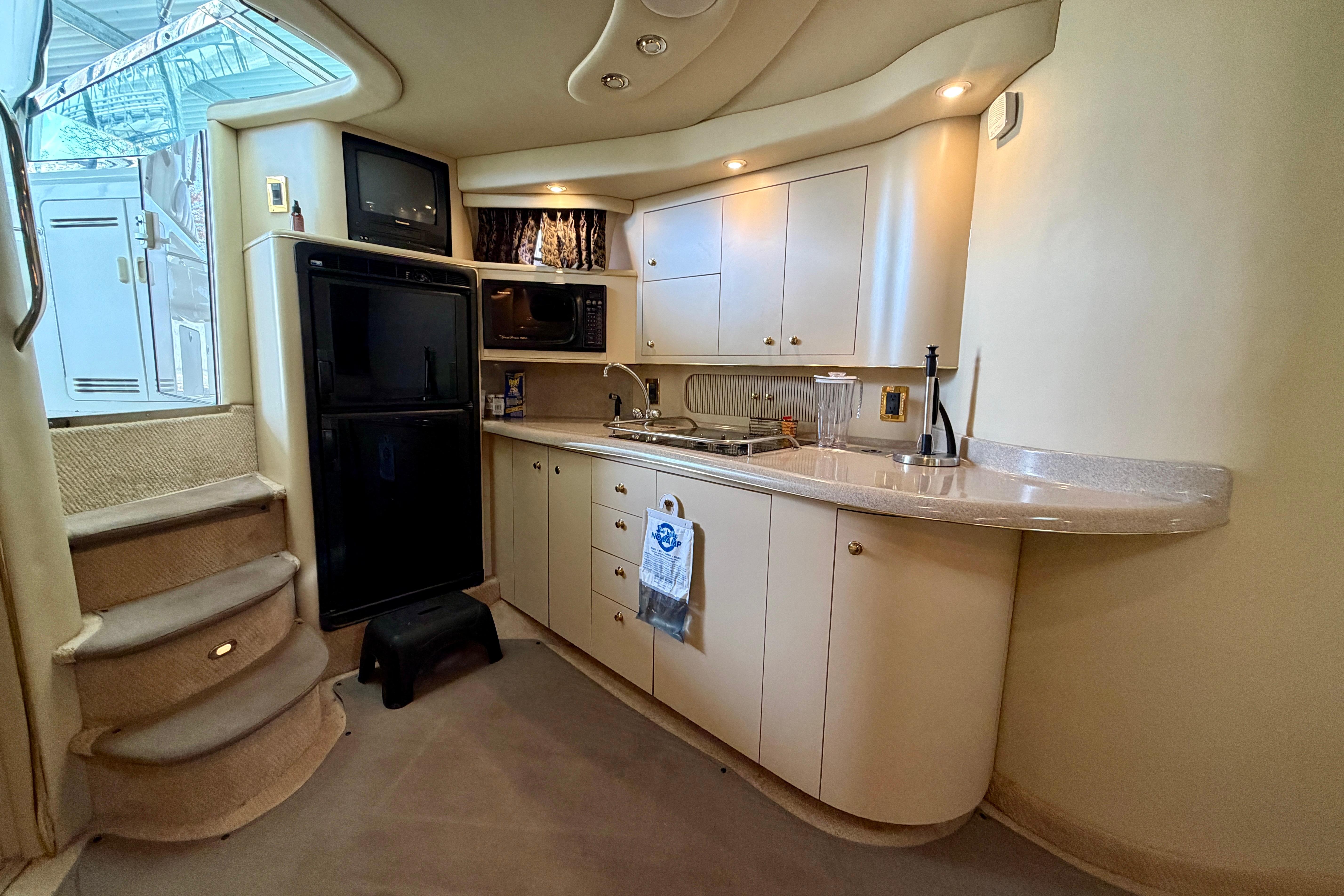 1999 Sea Ray 400 Sundancer yacht interior kitchen with modern amenities and elegant design.