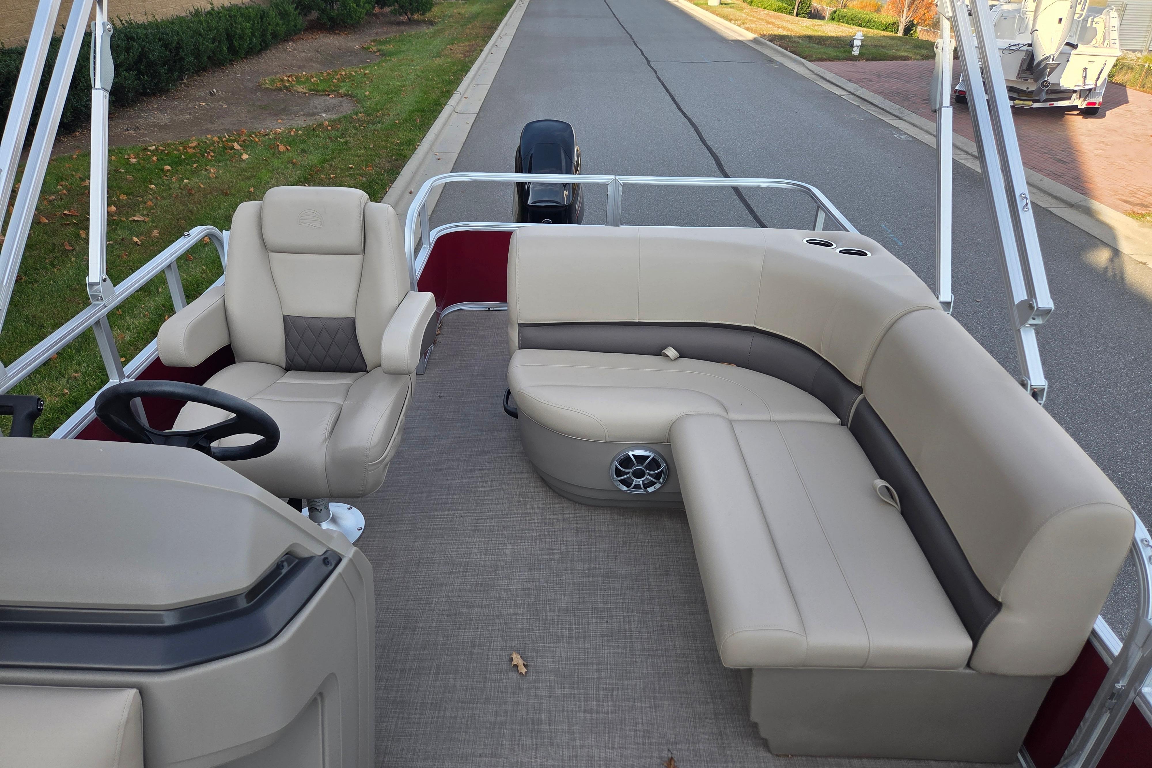 2025 Sun Tracker Party Barge 18 DLX interior with beige seating and steering wheel.