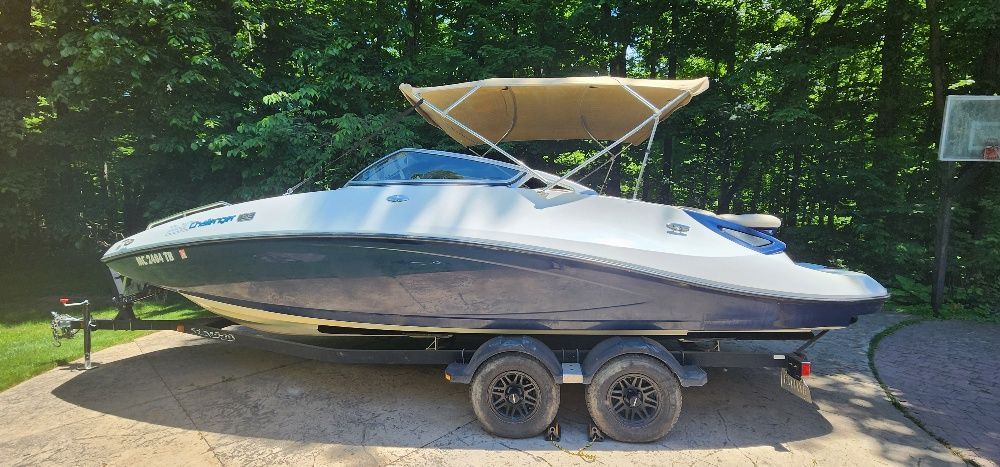 A 2007 Sea-Doo Sport Boat 230 Challenger SE on a trailer, surrounded by trees.