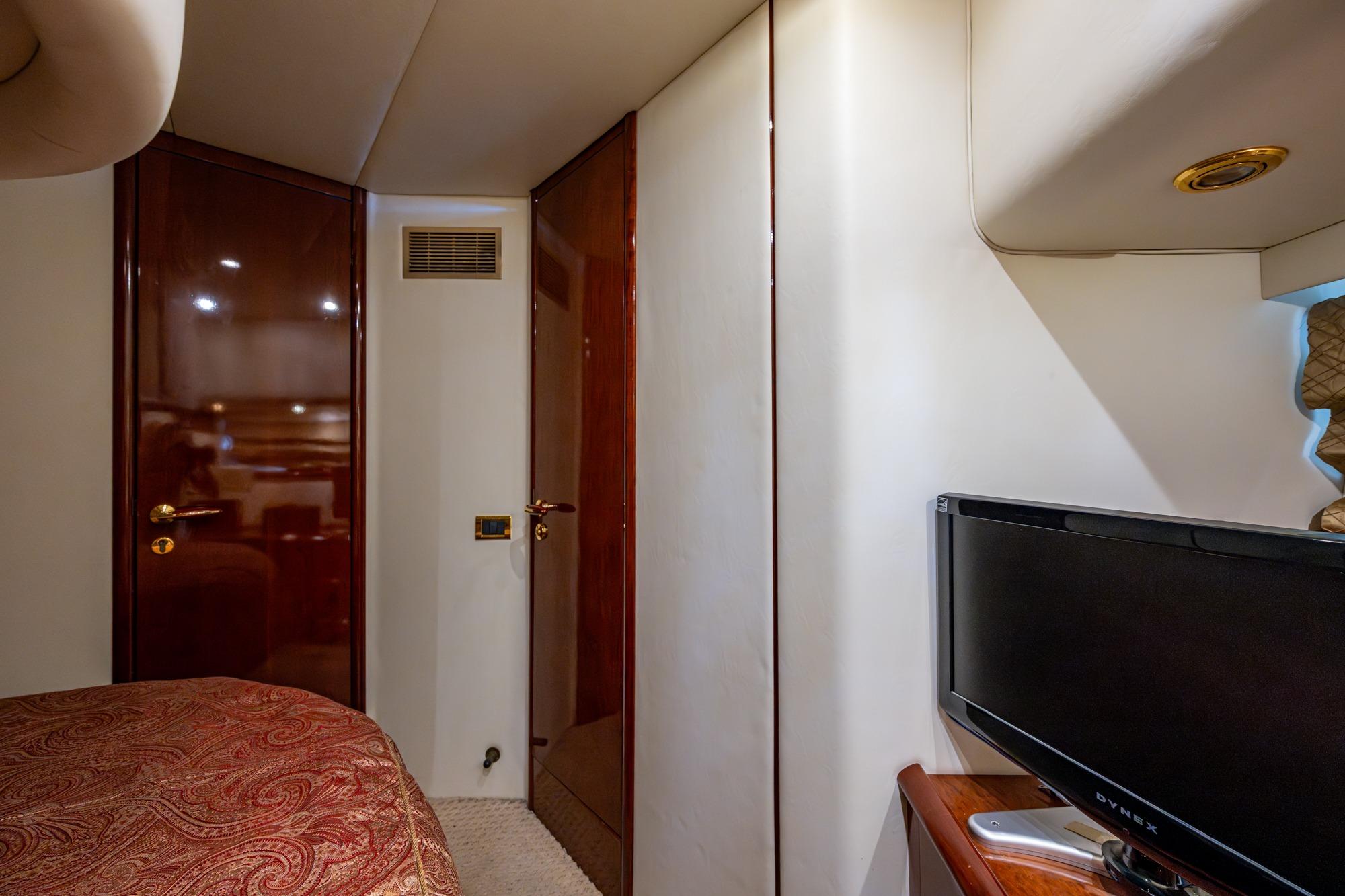 Interior of 2000 Fairline Squadron 52 yacht cabin with TV and wooden doors.