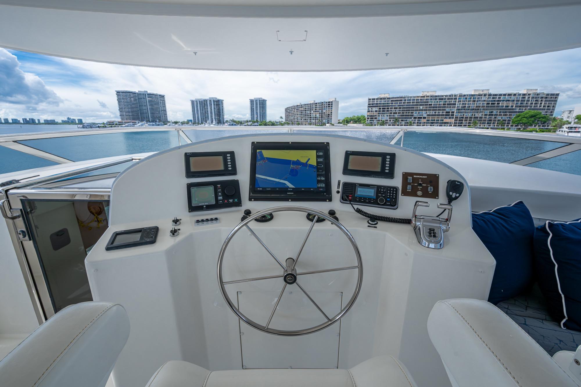 Helm of 2006 Westport w112 yacht with navigation equipment and cityscape view.