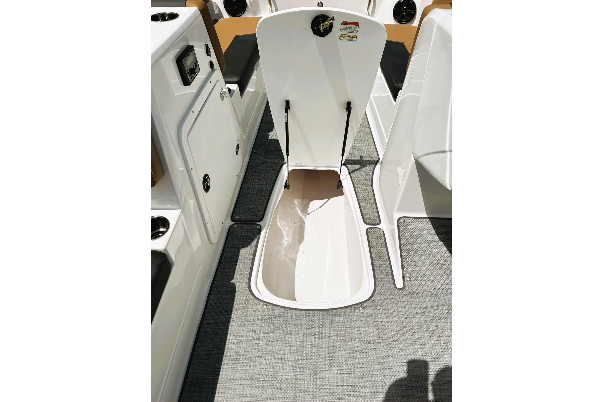 2026 Tahoe 2150 boat interior storage compartment with open hatch and seating area.