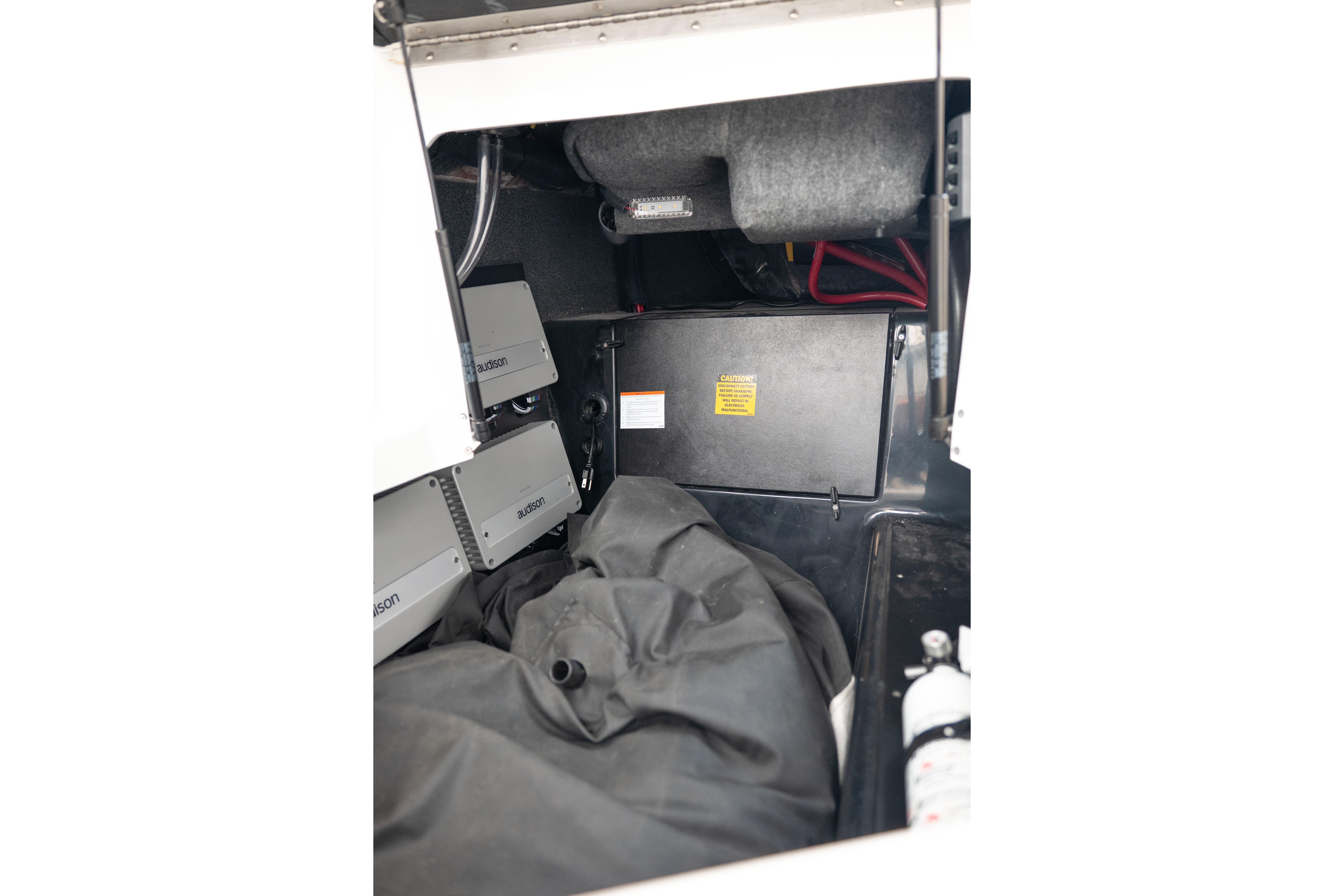 Interior view of 2024 Tigé Z5 boat storage compartment with equipment and safety gear.