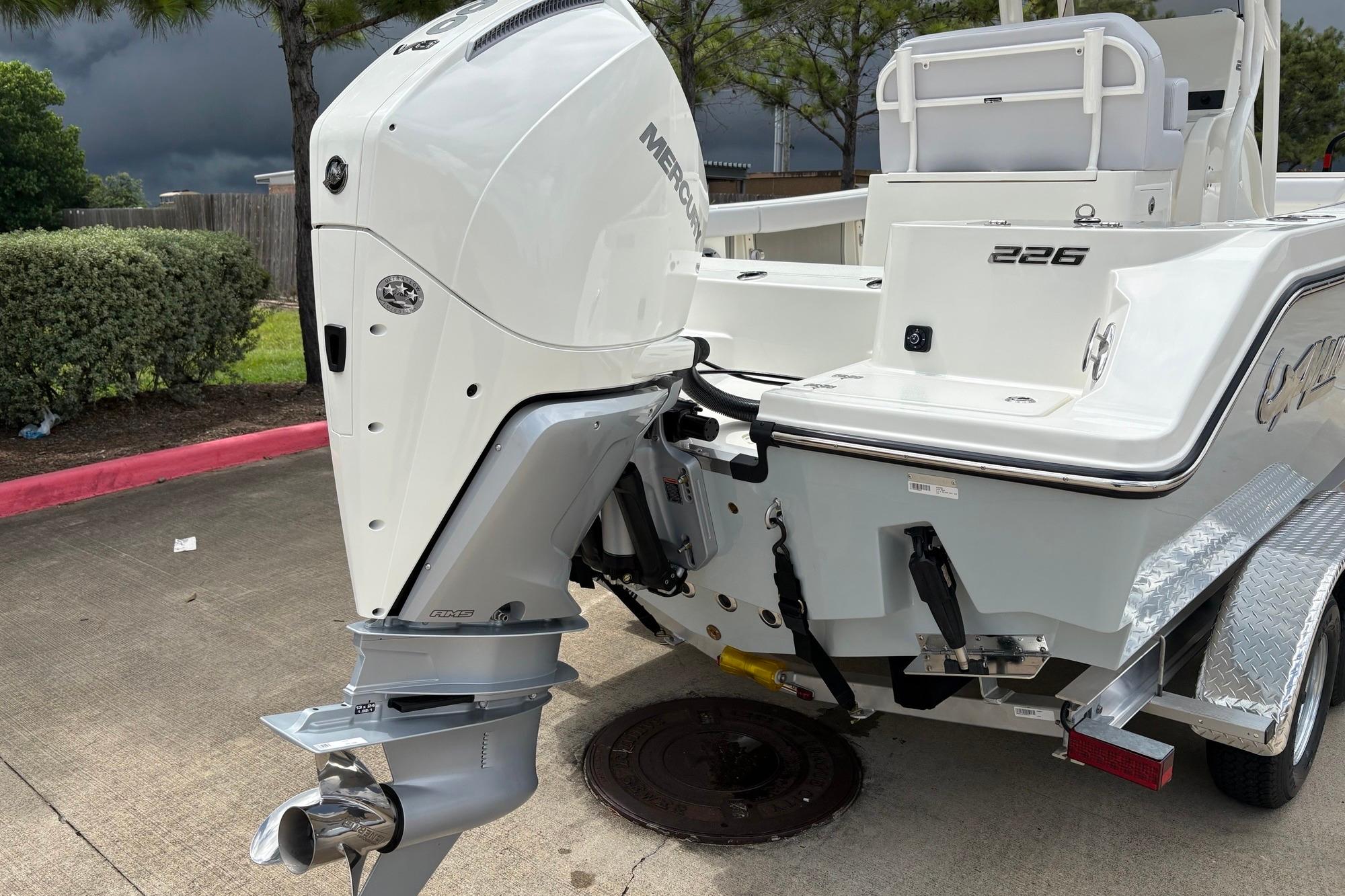 2026 Mako 226 Center Console boat with powerful outboard motor, parked on a trailer.