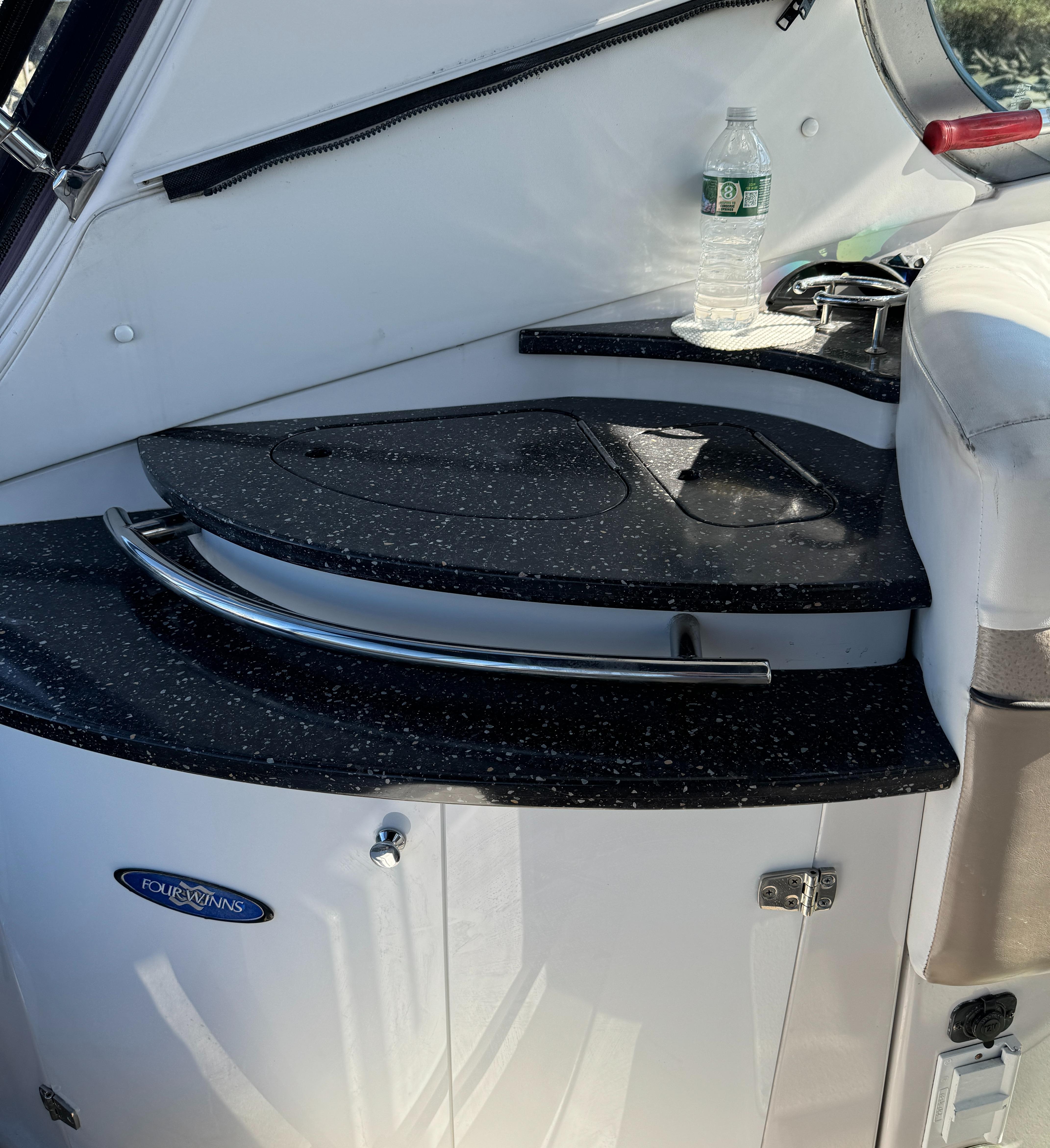 2007 Four Winns 318 Vista boat interior with sleek black countertop and water bottle.