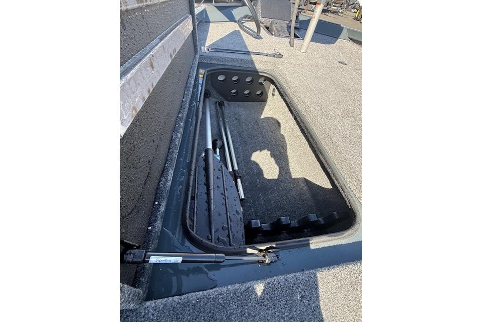 2026 Ranger RT198P boat storage compartment with fishing rod holders and carpeted interior.
