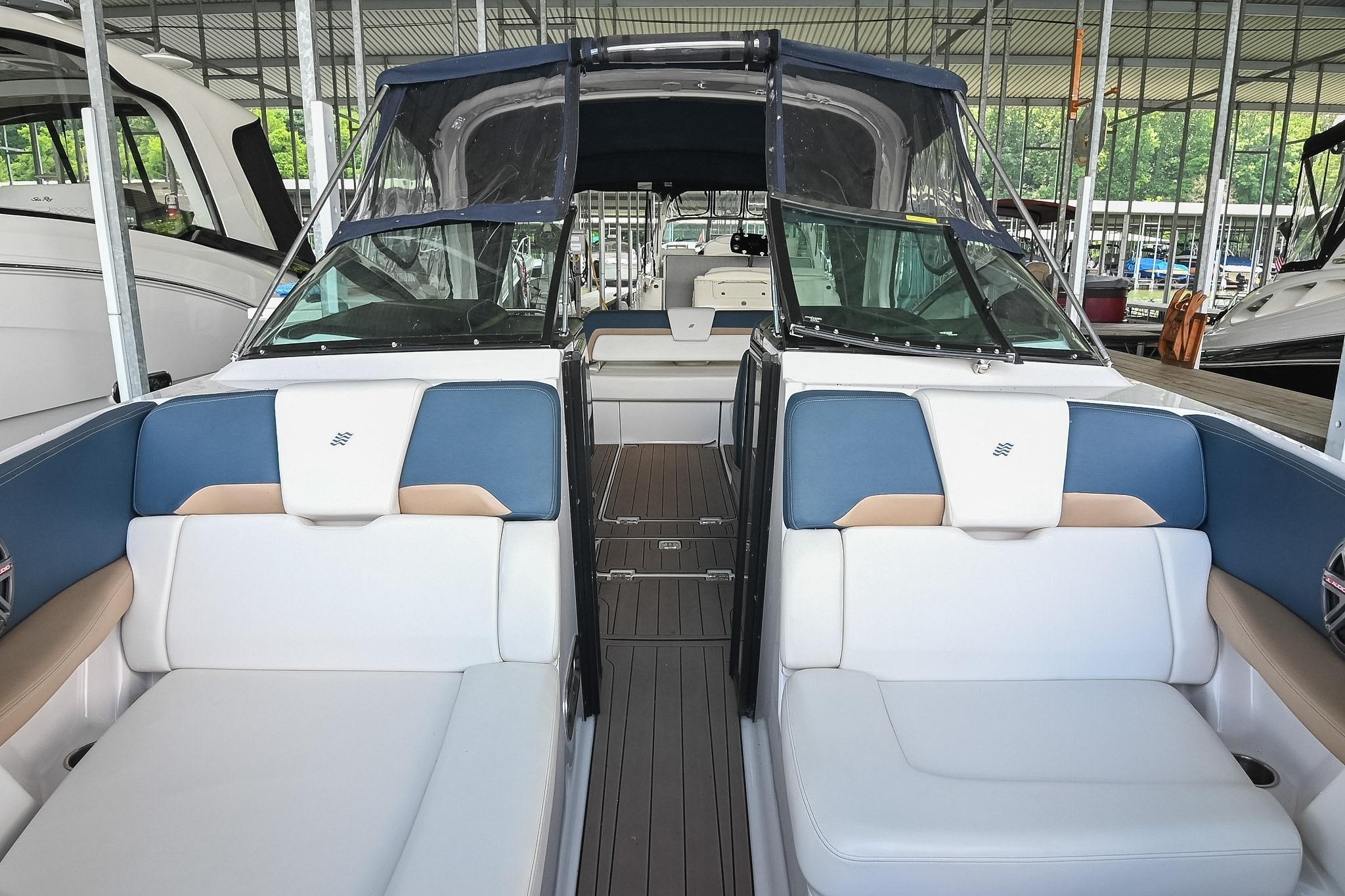 2014 Four Winns H290 boat interior with blue and white seating in a marina.