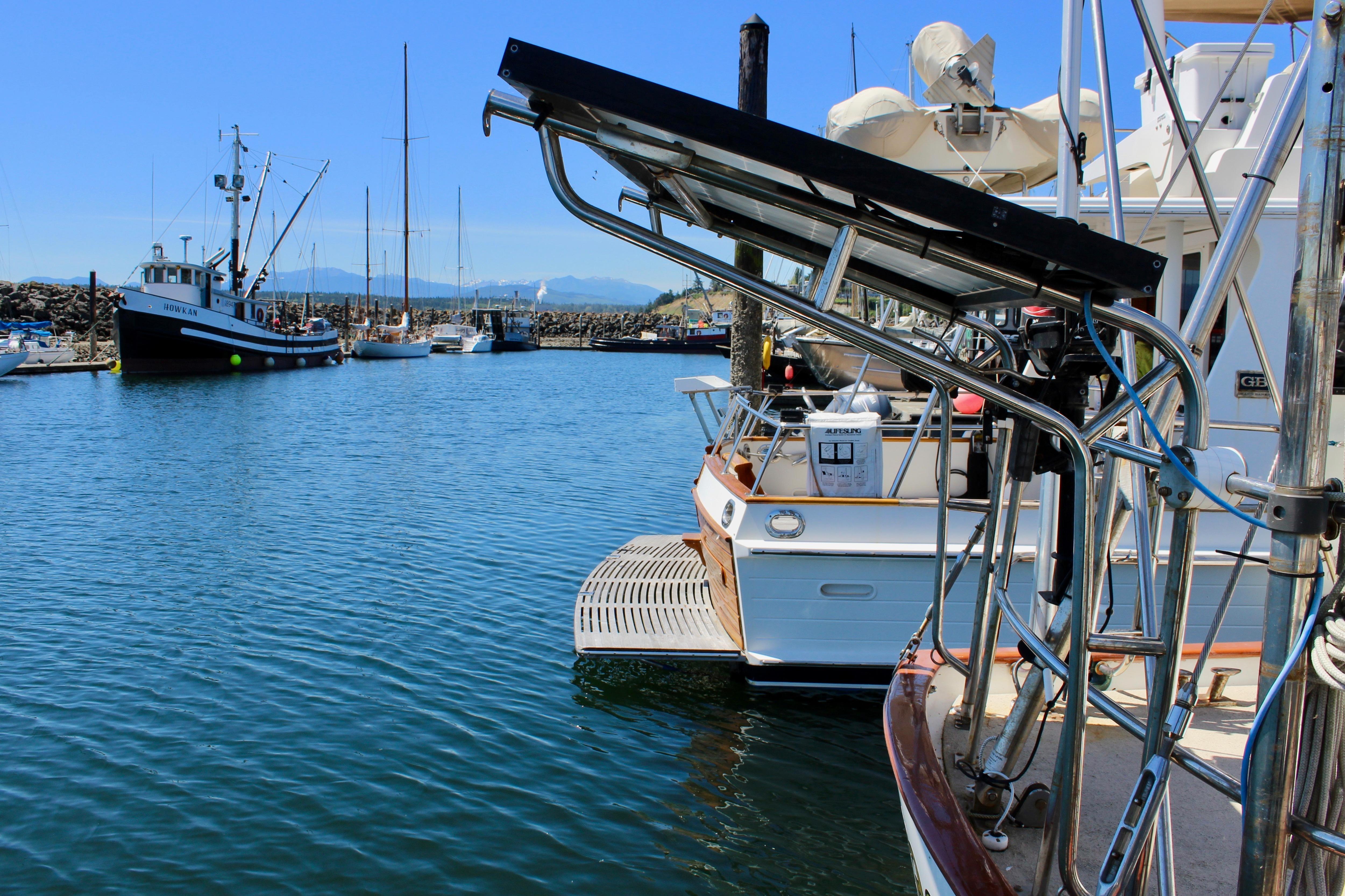 Marina with boats, including a 1981 Kelly Peterson 46, under clear blue skies.