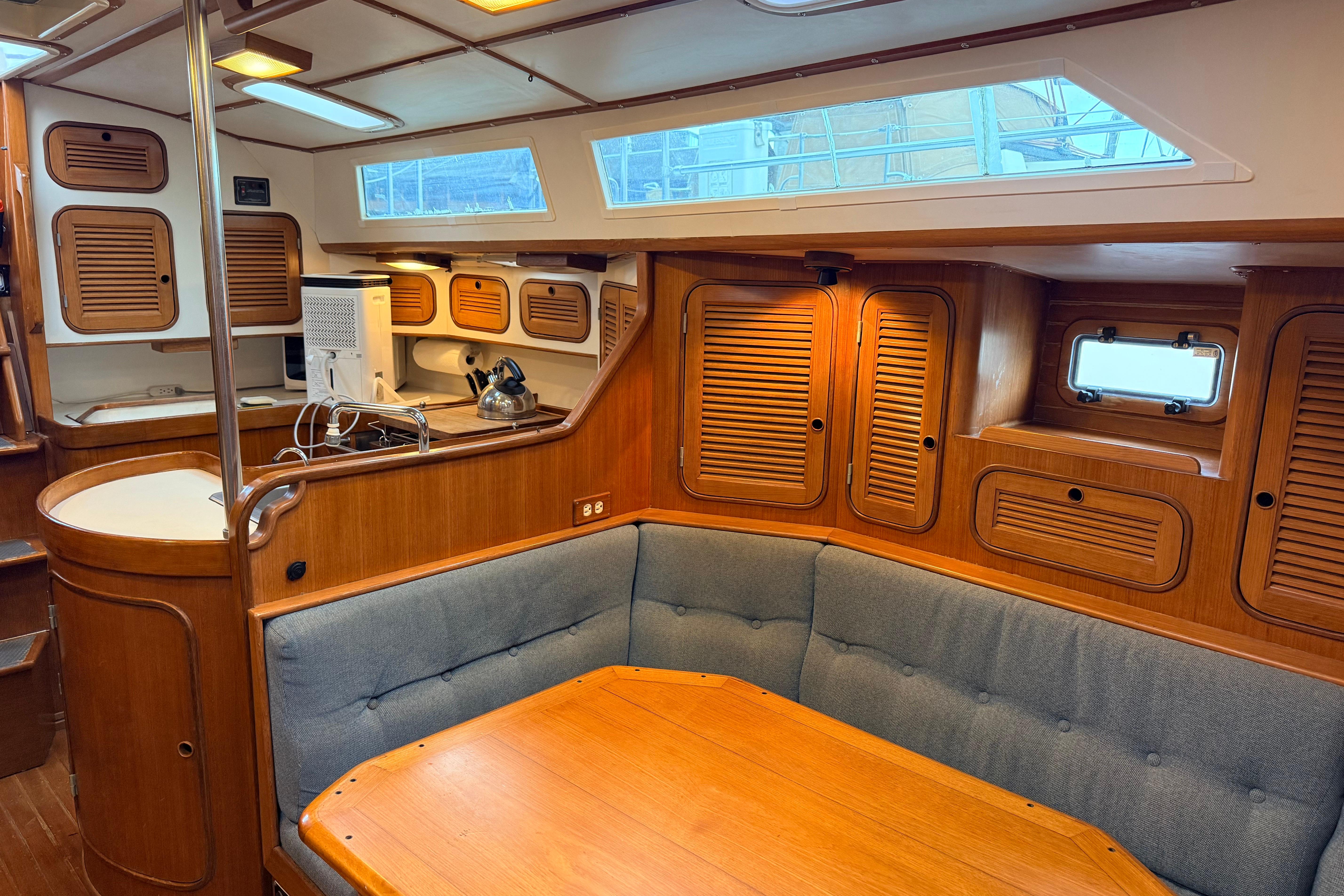 Interior of 1987 Norseman 400 sailboat with wooden cabinetry and cozy seating area.