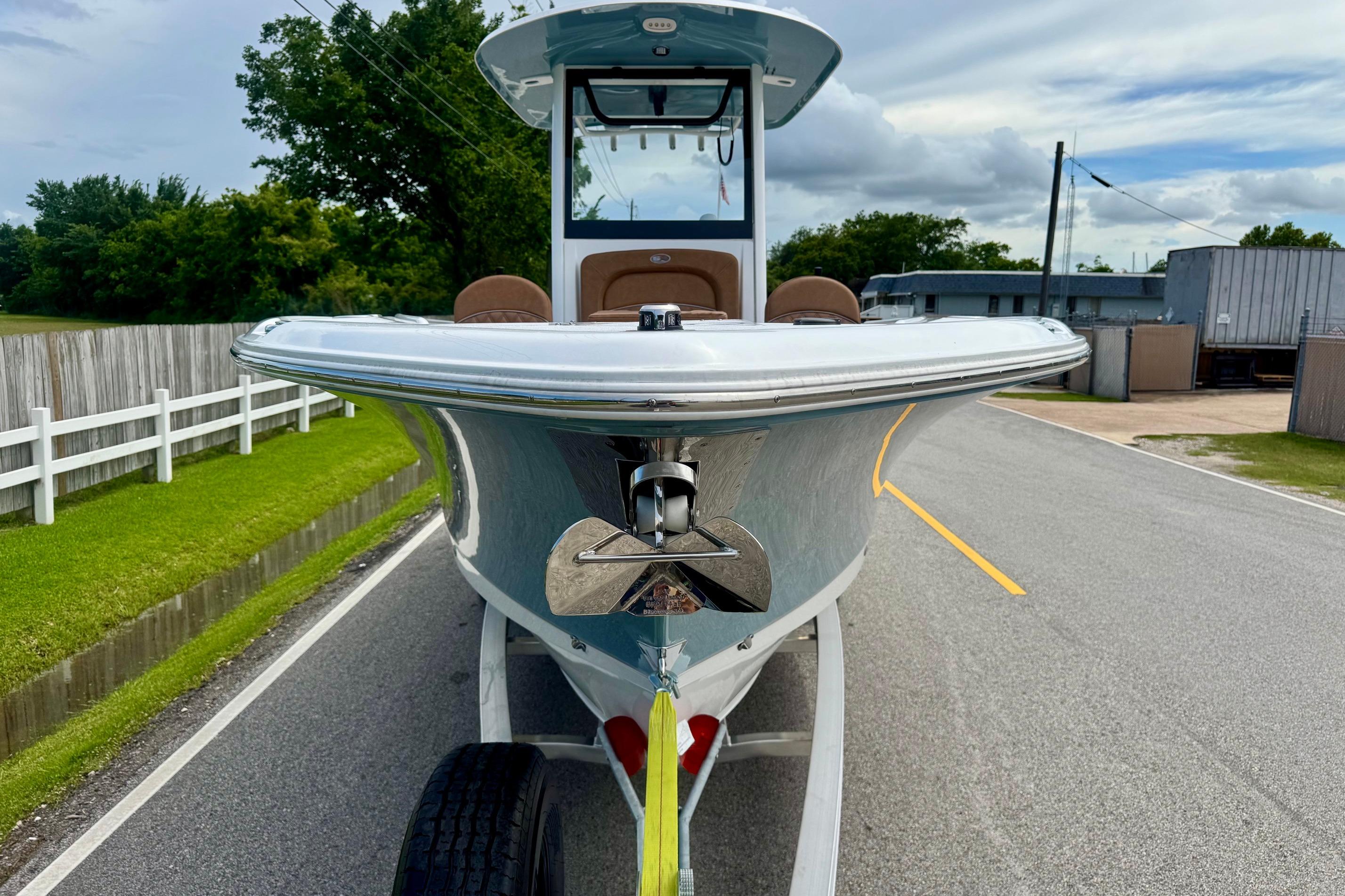 2026 Sea Hunt Ultra 275 SE boat on trailer, parked on a road with greenery.