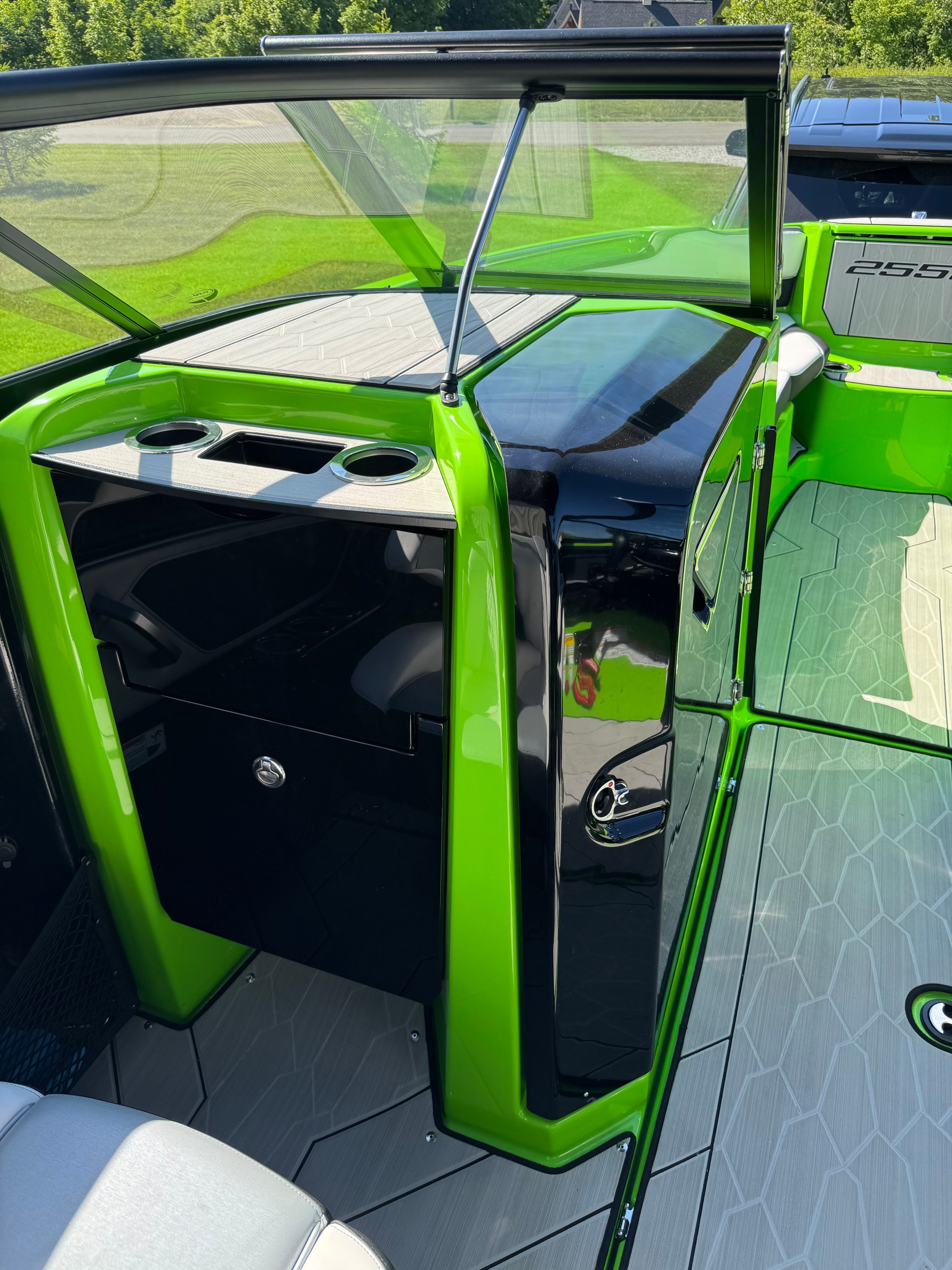 The image shows the cockpit of a 2022 Yamaha 255XD boat with green and black design.