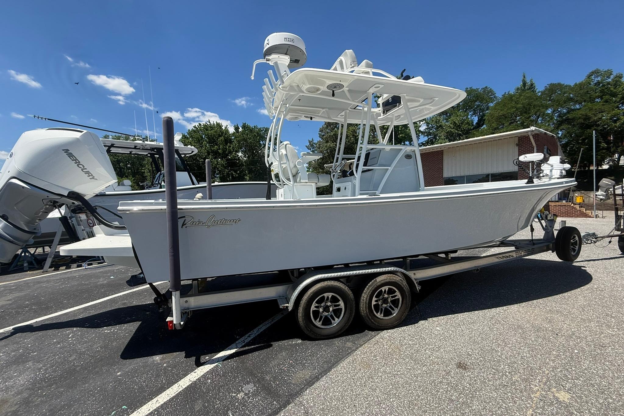 2024 Pair Customs 24 Center Console MV boat on trailer, parked outdoors.