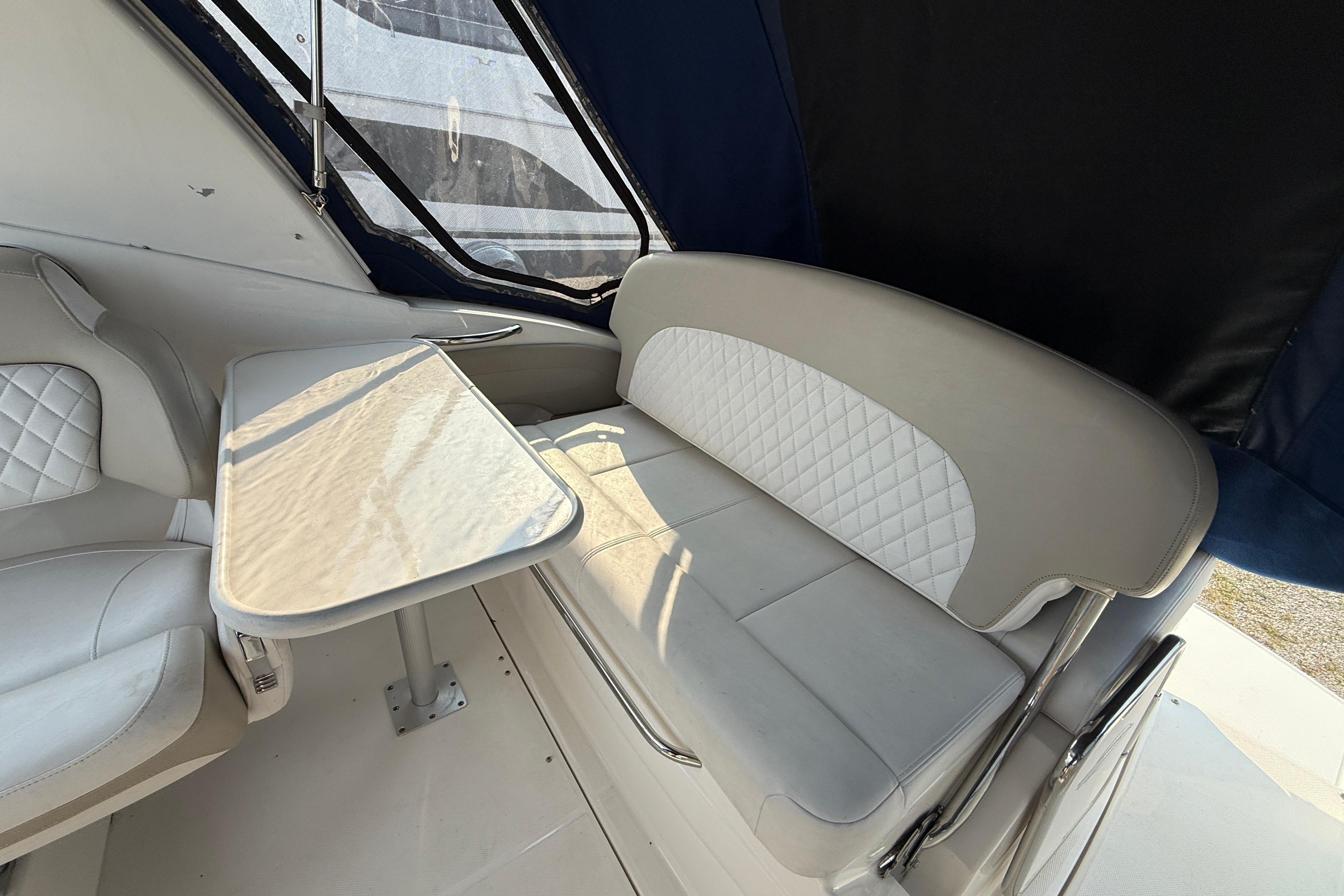 Interior of 2014 Chaparral 270 Signature boat with white seating and table.