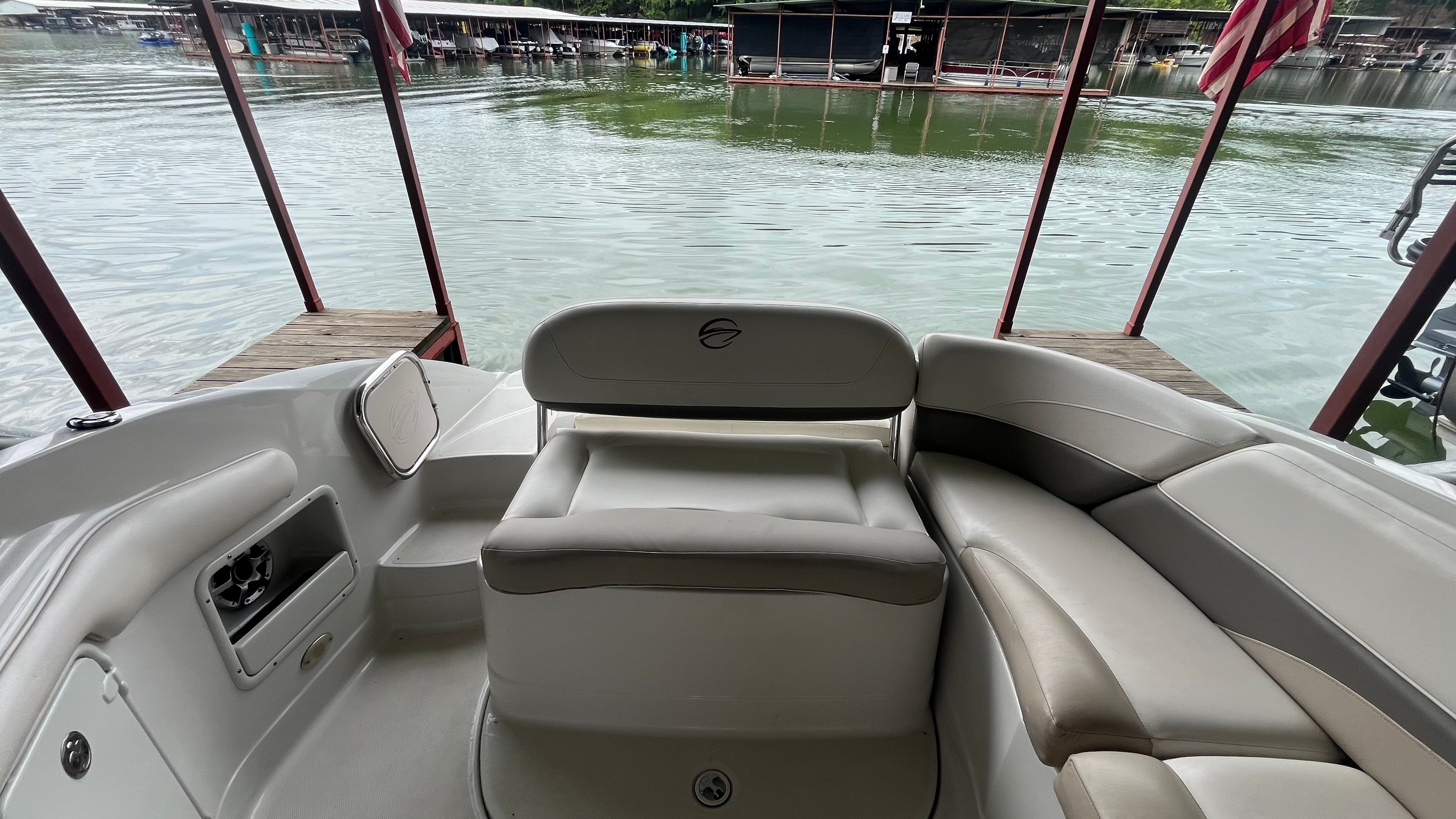 The image shows the cockpit of a 2008 Crownline 252EX boat docked by the water.