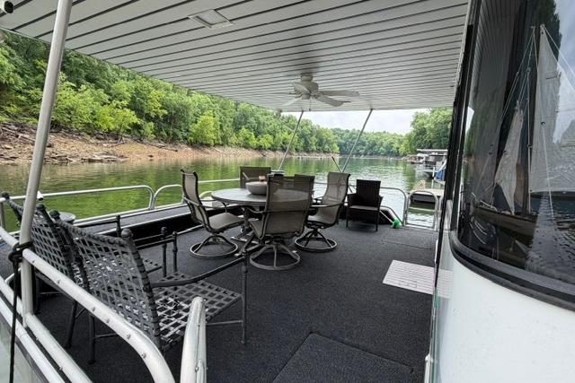 1997 Stardust Houseboat 18x83 with outdoor seating on a serene lake.
